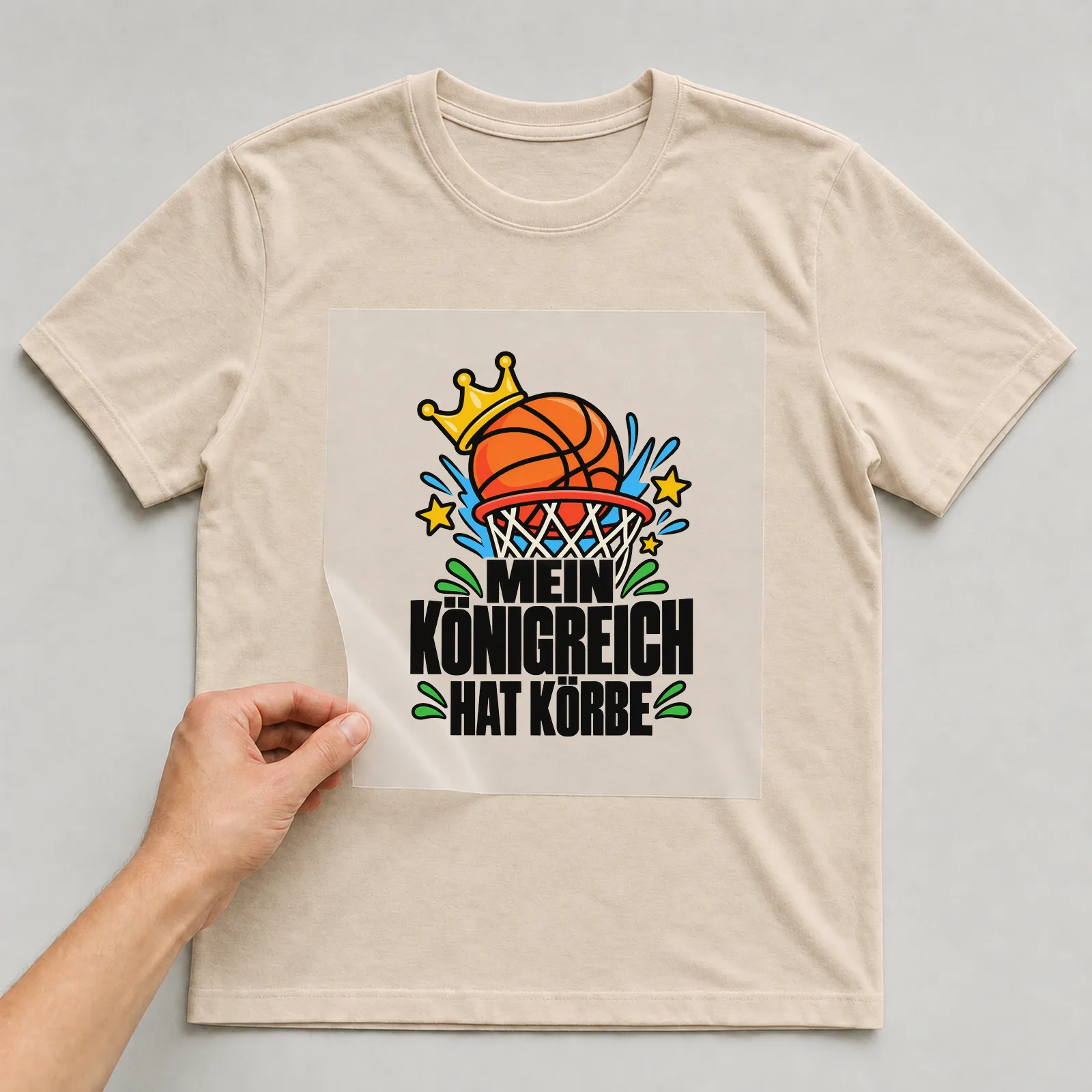 Bügelbild „Mein Königreich hat Körbe“ auf beigem T-Shirt, Folie wird aufgelegt