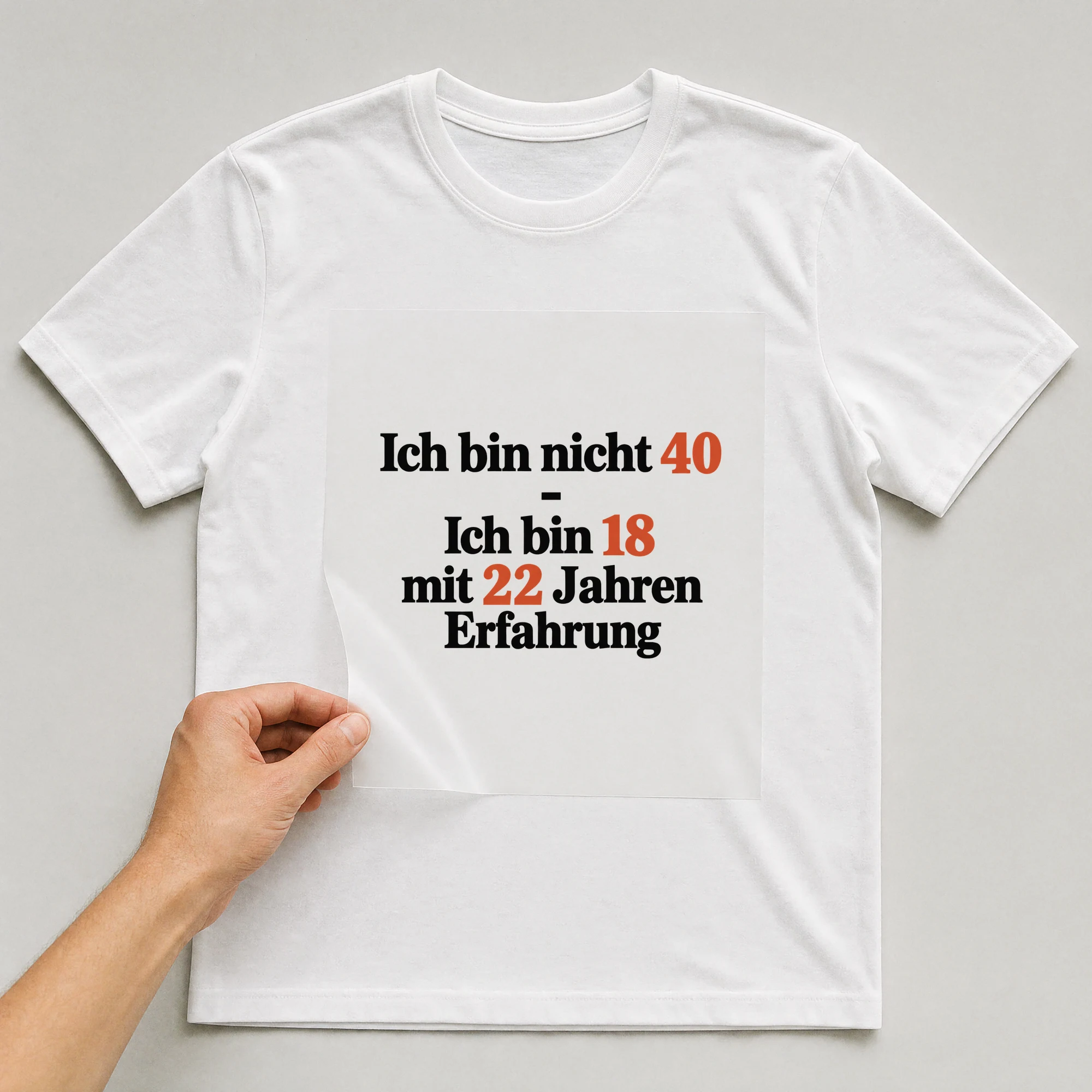 Bügelbild „Ich bin nicht 40 - Ich bin 18 mit 22 Jahren Erfahrung“ auf weißem T-Shirt, Folie wird aufgelegt