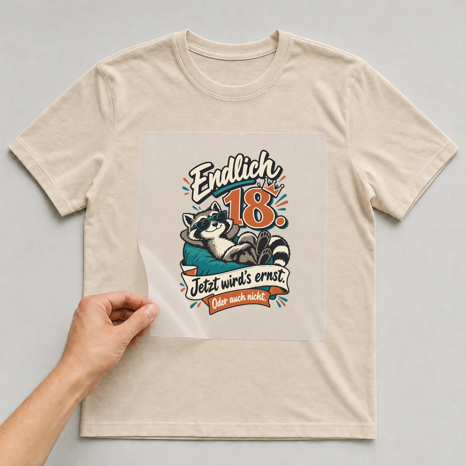 Bügelbild Endlich 18. Jetzt wird’s ernst. Oder auch nicht. auf beigem T-Shirt, Folie wird aufgelegt