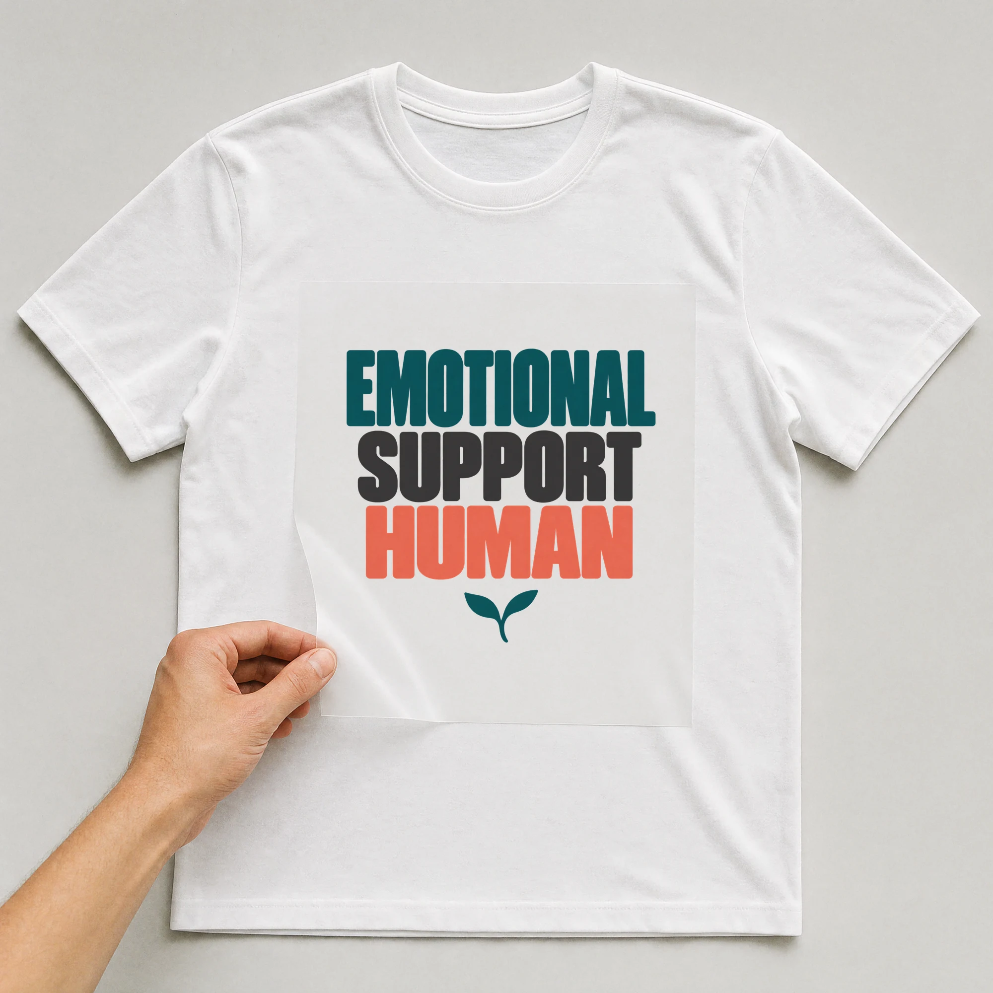 Bügelbild „EMOTIONAL SUPPORT HUMAN“ auf weißem T-Shirt, Folie wird aufgelegt