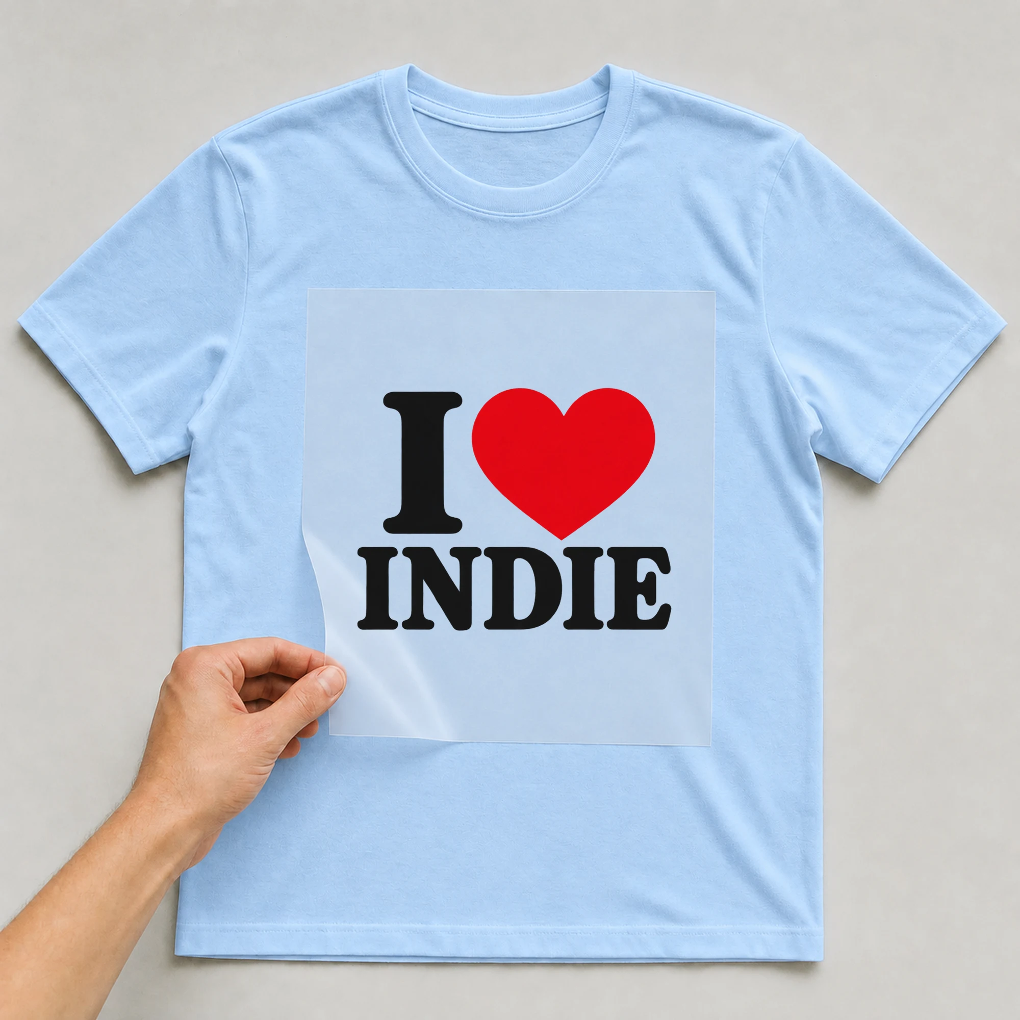 Bügelbild „I Indie“ auf babyblauem T-Shirt, Folie wird aufgelegt