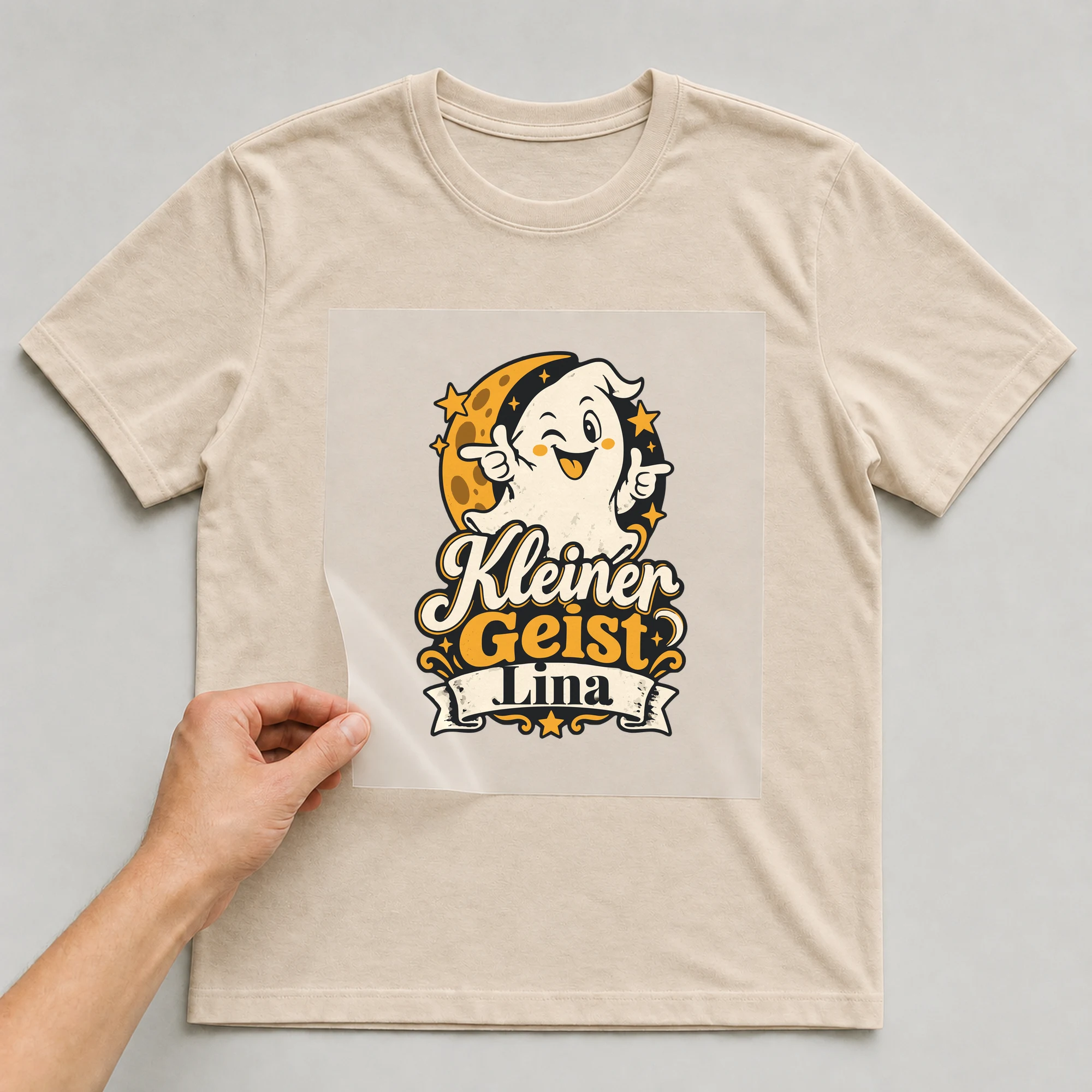 Bügelbild Kleiner Geist mit Name auf beigem T-Shirt, Folie wird aufgelegt