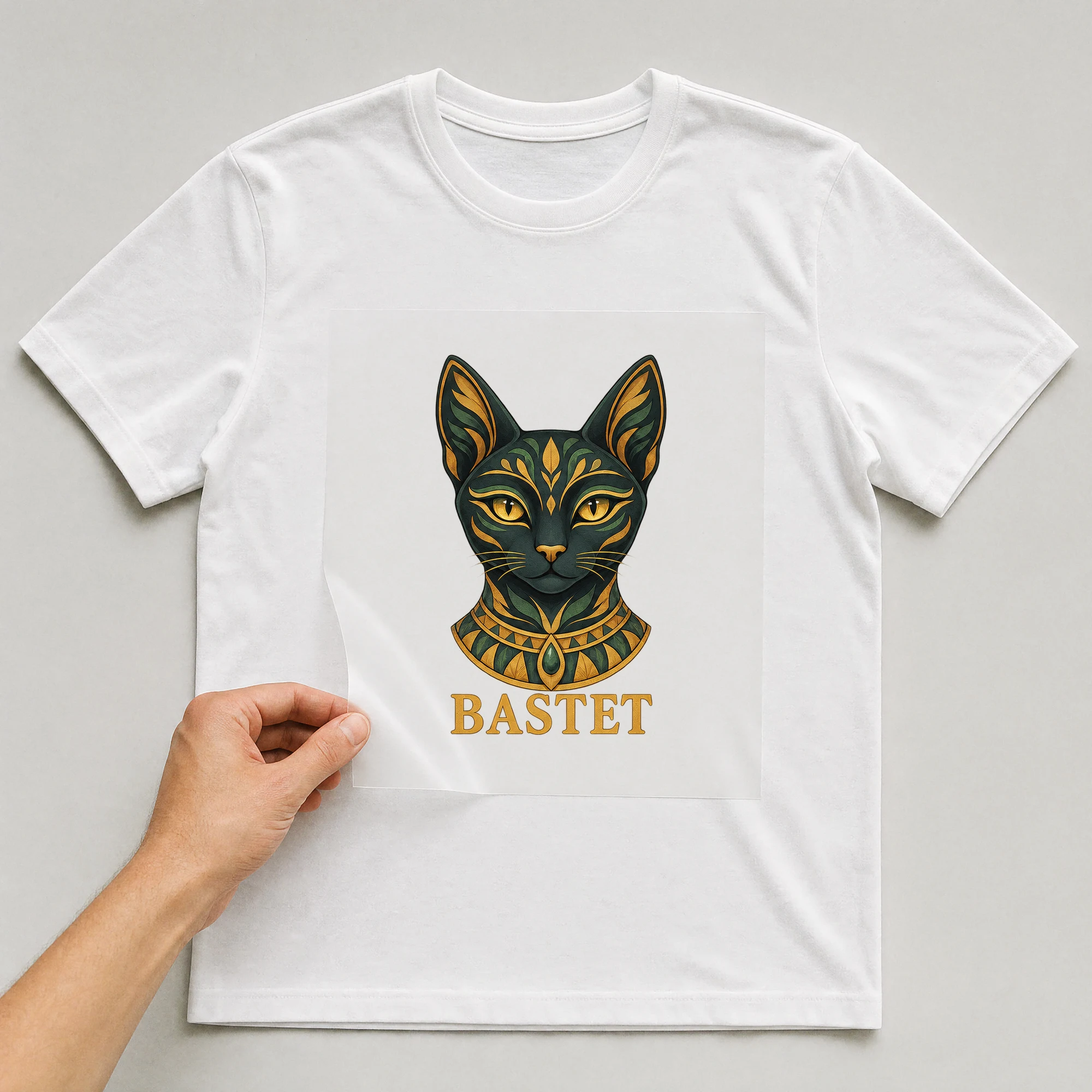 Bügelbild „Bastet“ auf weißem T-Shirt, Folie wird aufgelegt