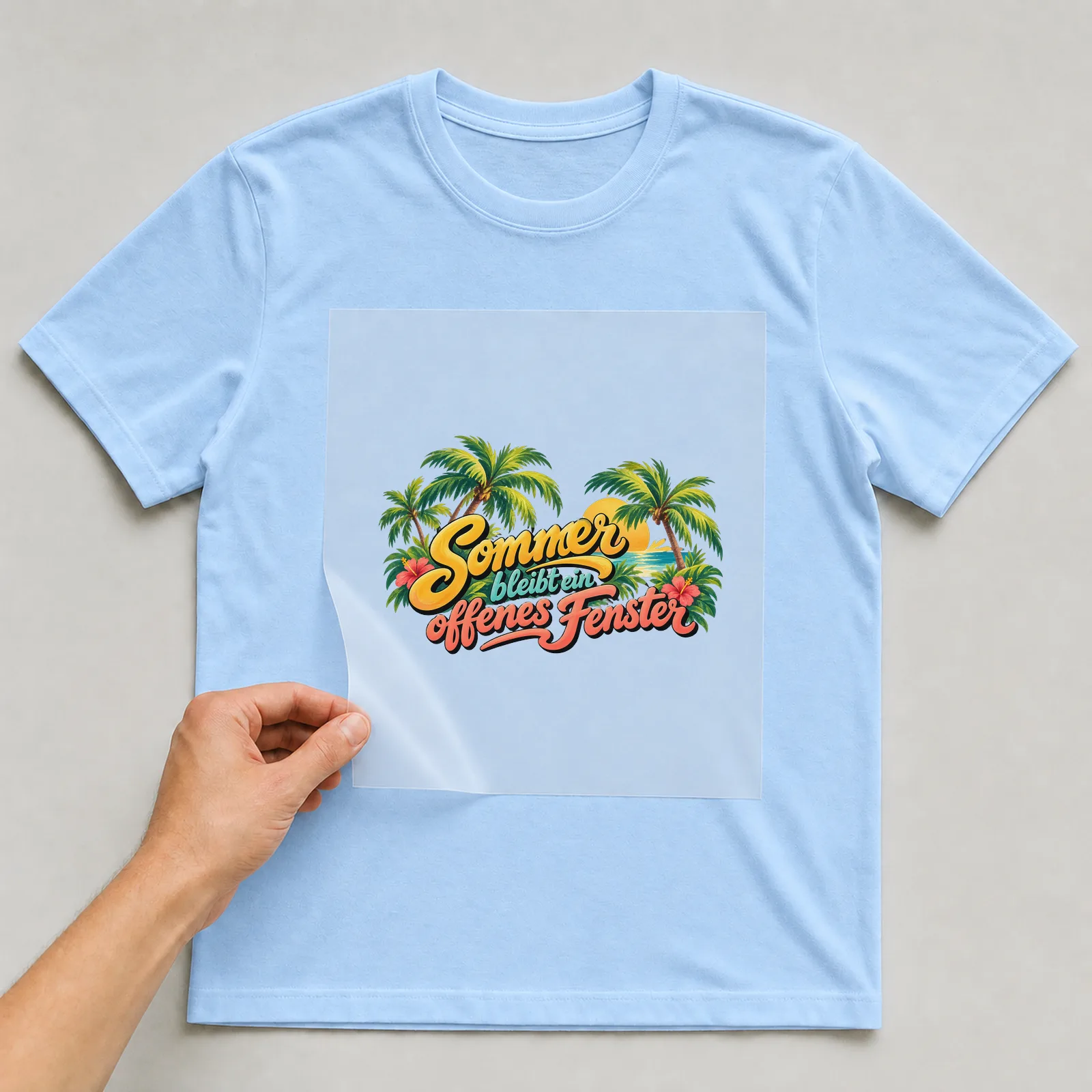 Bügelbild „Sommer bleibt ein offenes Fenster“ auf hellblauem T-Shirt, Folie wird aufgelegt