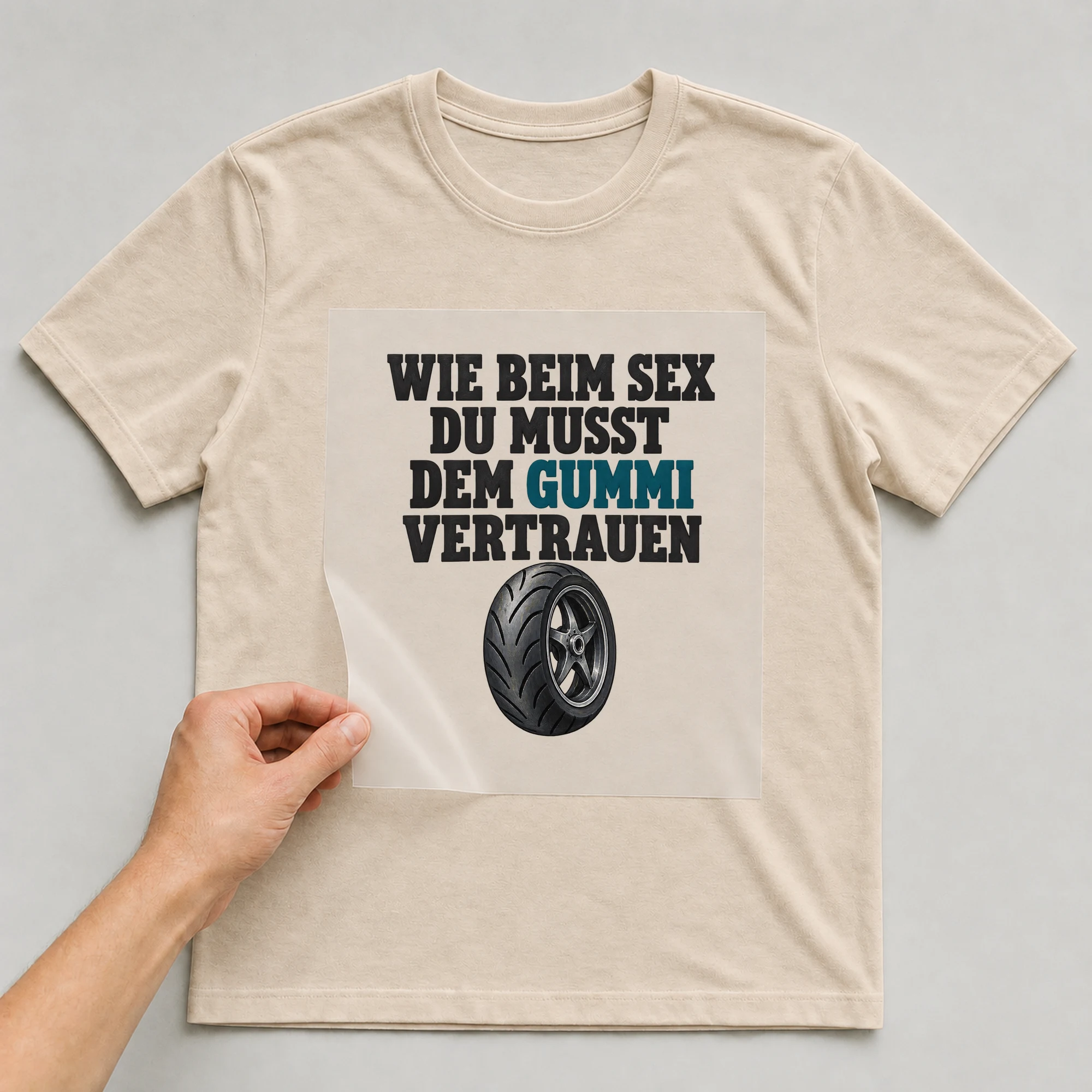 Bügelbild „Wie beim Sex du musst dem Gummi vertrauen“ auf beigem T-Shirt, Folie wird aufgelegt