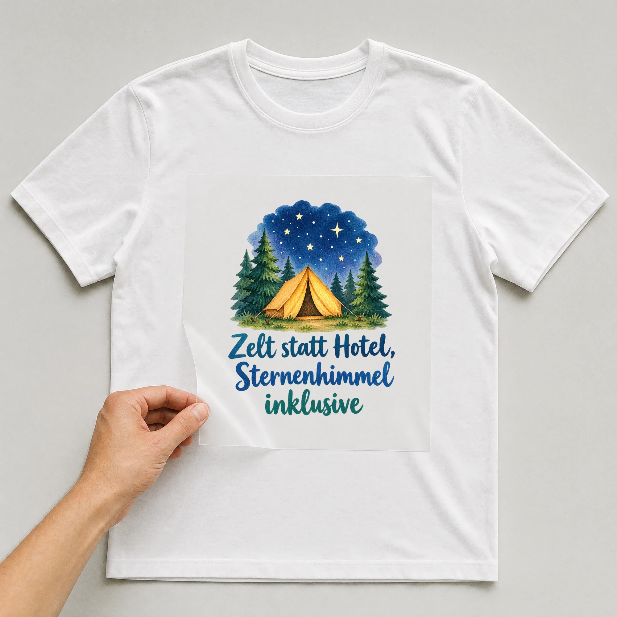 Bügelbild „Zelt statt hotel sternenhimmel inklusive“ auf weißem T-Shirt, Folie wird aufgelegt