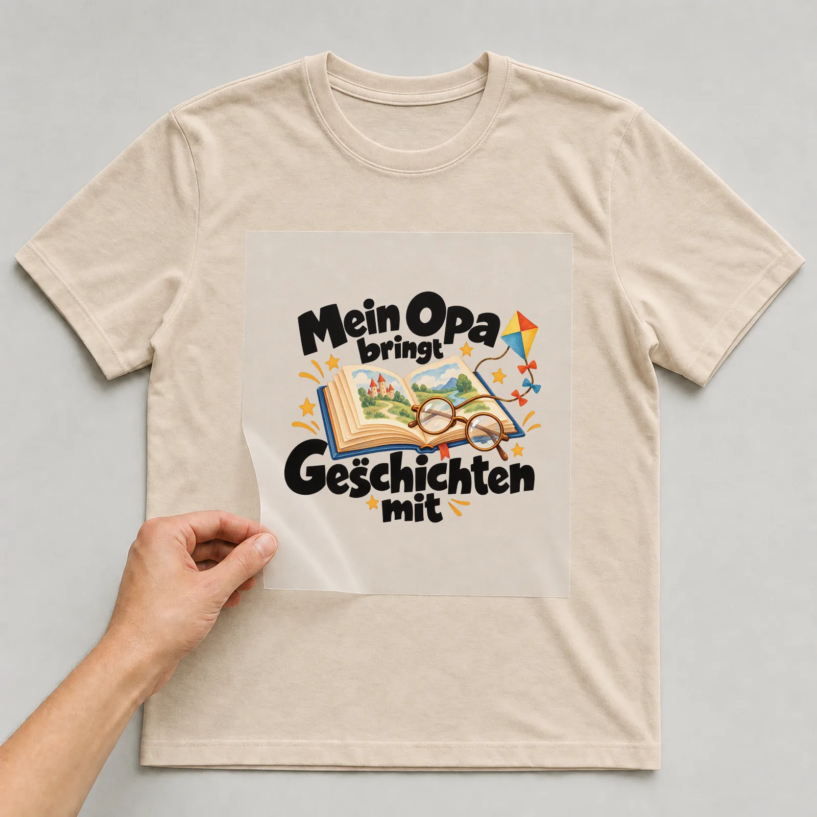 Bügelbild „Mein Opa bringt Geschichten mit“ auf beigem T-Shirt, Folie wird aufgelegt