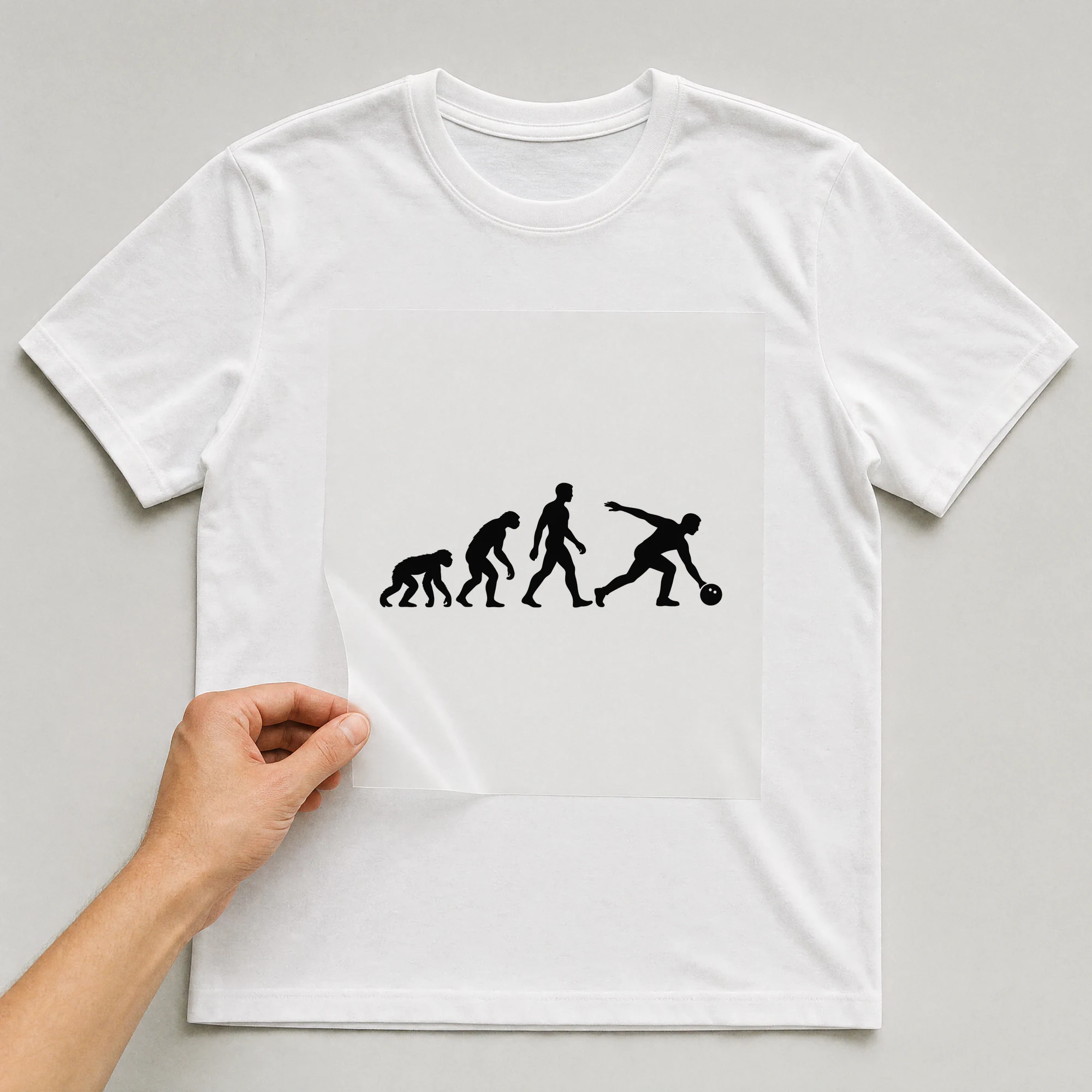 Bügelbild „Evolution Bowling“ auf weißem T-Shirt, Folie wird aufgelegt