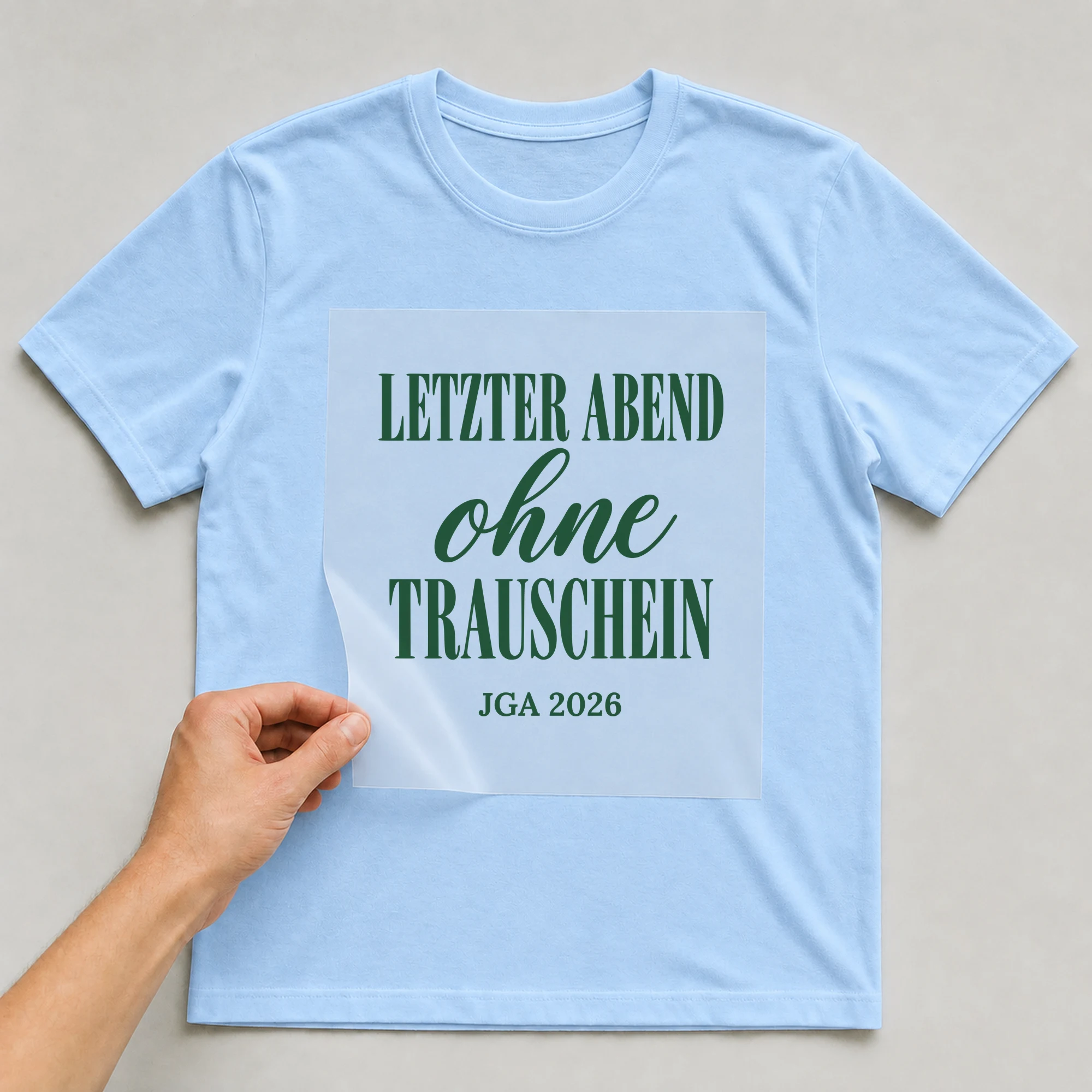 Bügelbild Letzter Abend ohne Trauschein auf hellblauem T-Shirt, Folie wird aufgelegt