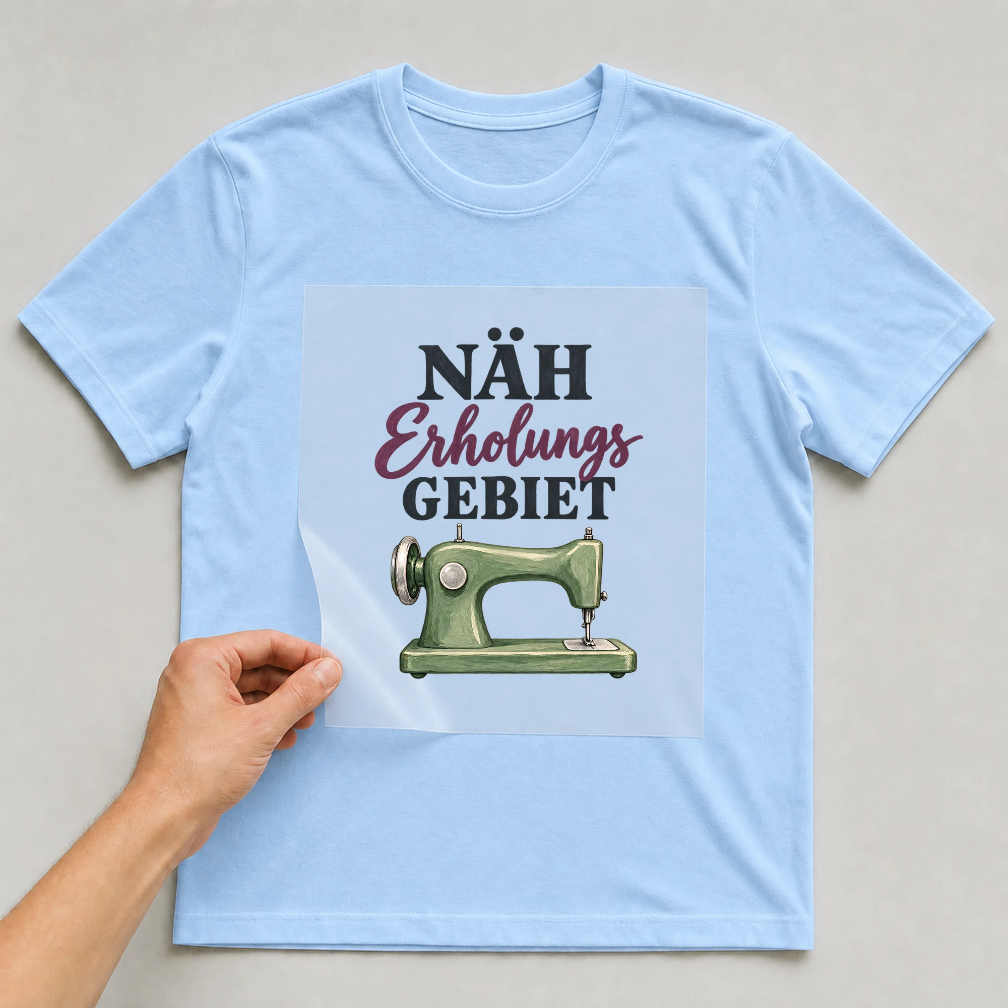 Bügelbild „Näh erholungs Gebiet“ auf babyblauem T-Shirt, Folie wird aufgelegt