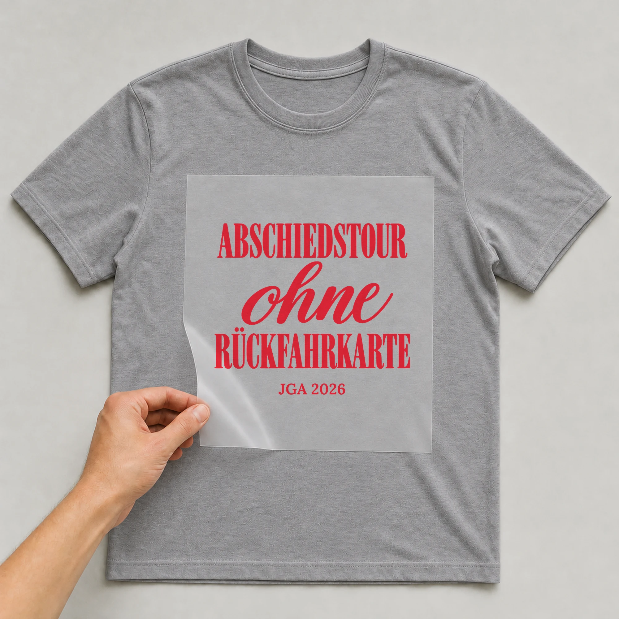 Bügelbild Abschiedstour ohne Rückfahrkarte mit Jahr auf grauem T-Shirt, Folie wird aufgelegt