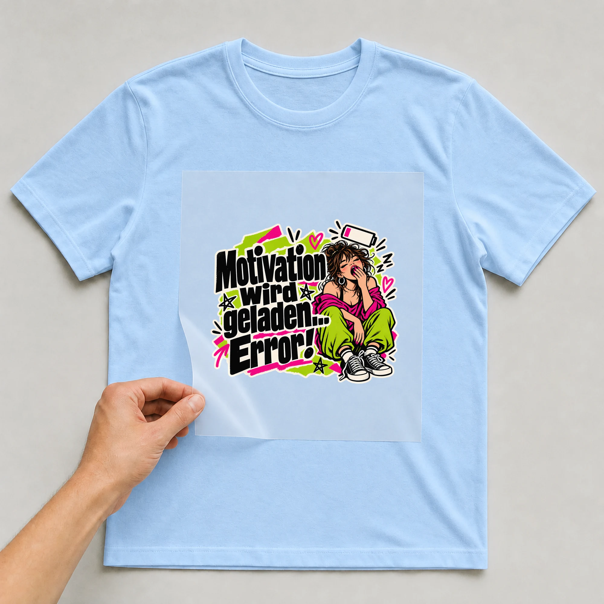 Bügelbild „Motivation wird geladen. Error!“ auf babyblauem T-Shirt, Folie wird aufgelegt
