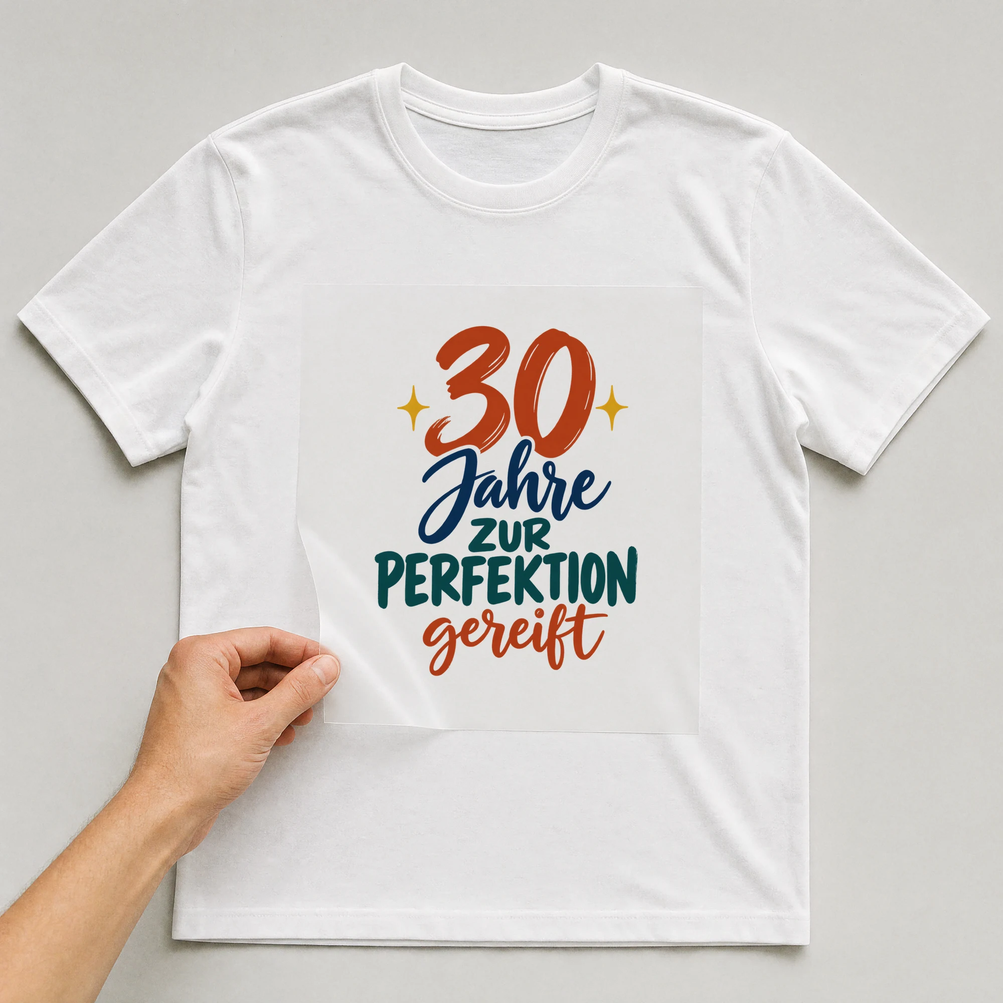 Bügelbild „30 Jahre zur Perfektion gereift“ auf weißem T-Shirt, Folie wird aufgelegt