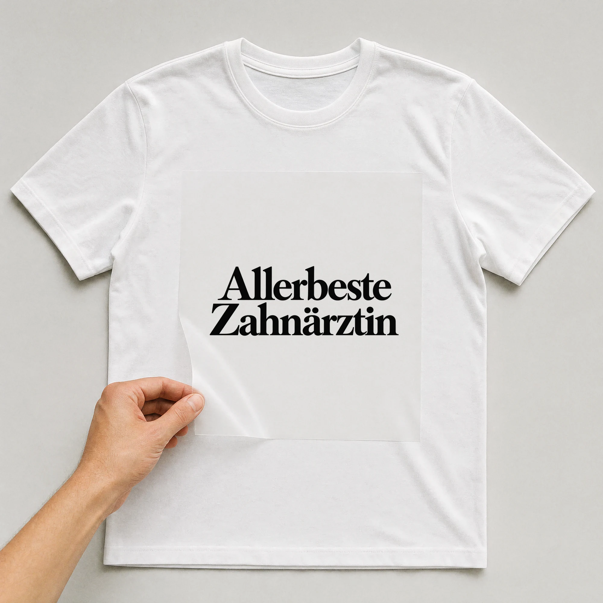 Bügelbild „Allerbeste Zahnärztin“ auf weißem T-Shirt, Folie wird aufgelegt
