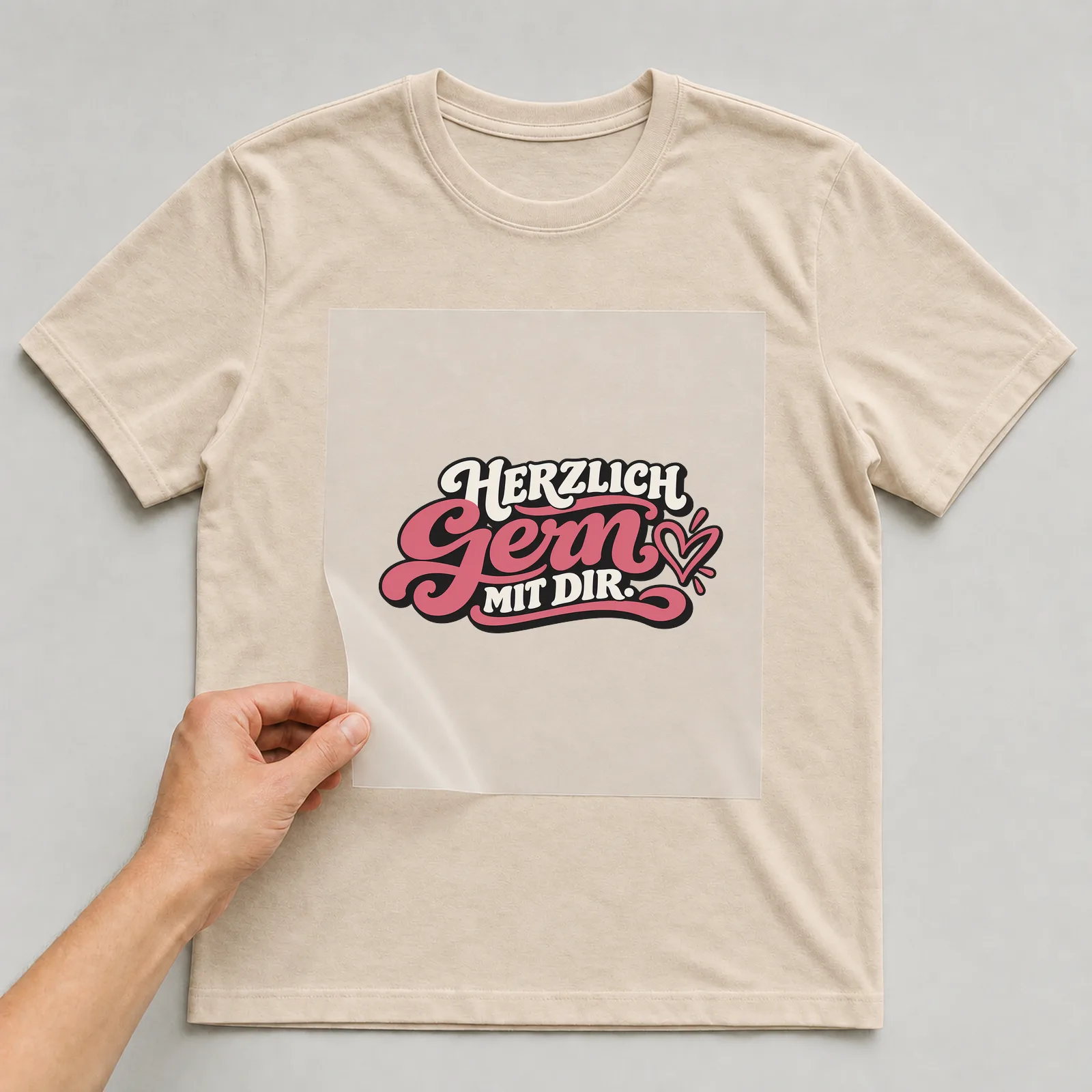 Bügelbild „Herzlich gern mit dir“ auf beigem T-Shirt, Folie wird aufgelegt