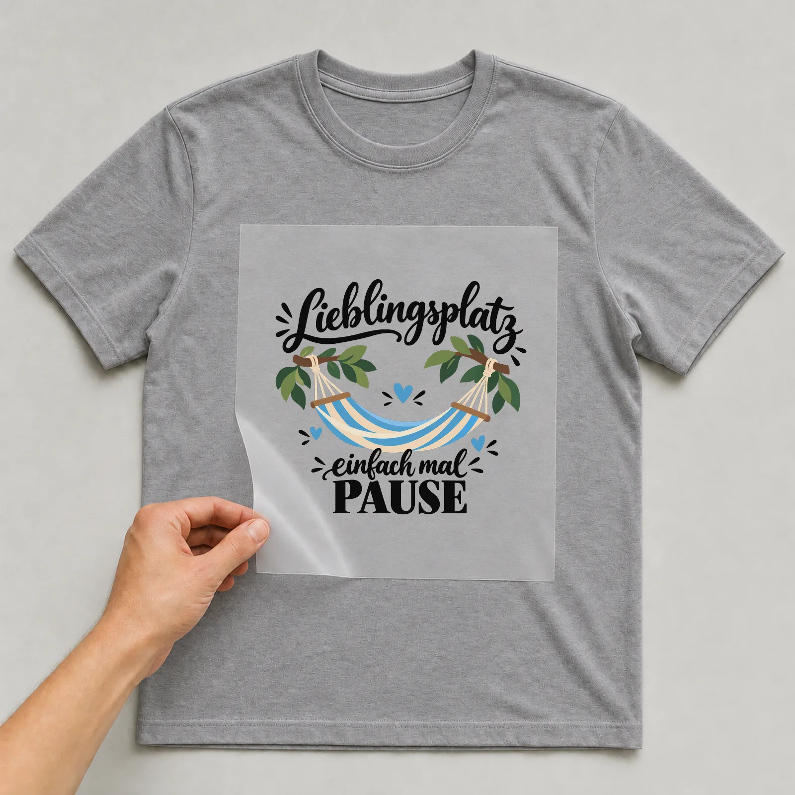 Bügelbild „Lieblingsplatz einfach mal Pause“ auf grauem T-Shirt, Folie wird aufgelegt