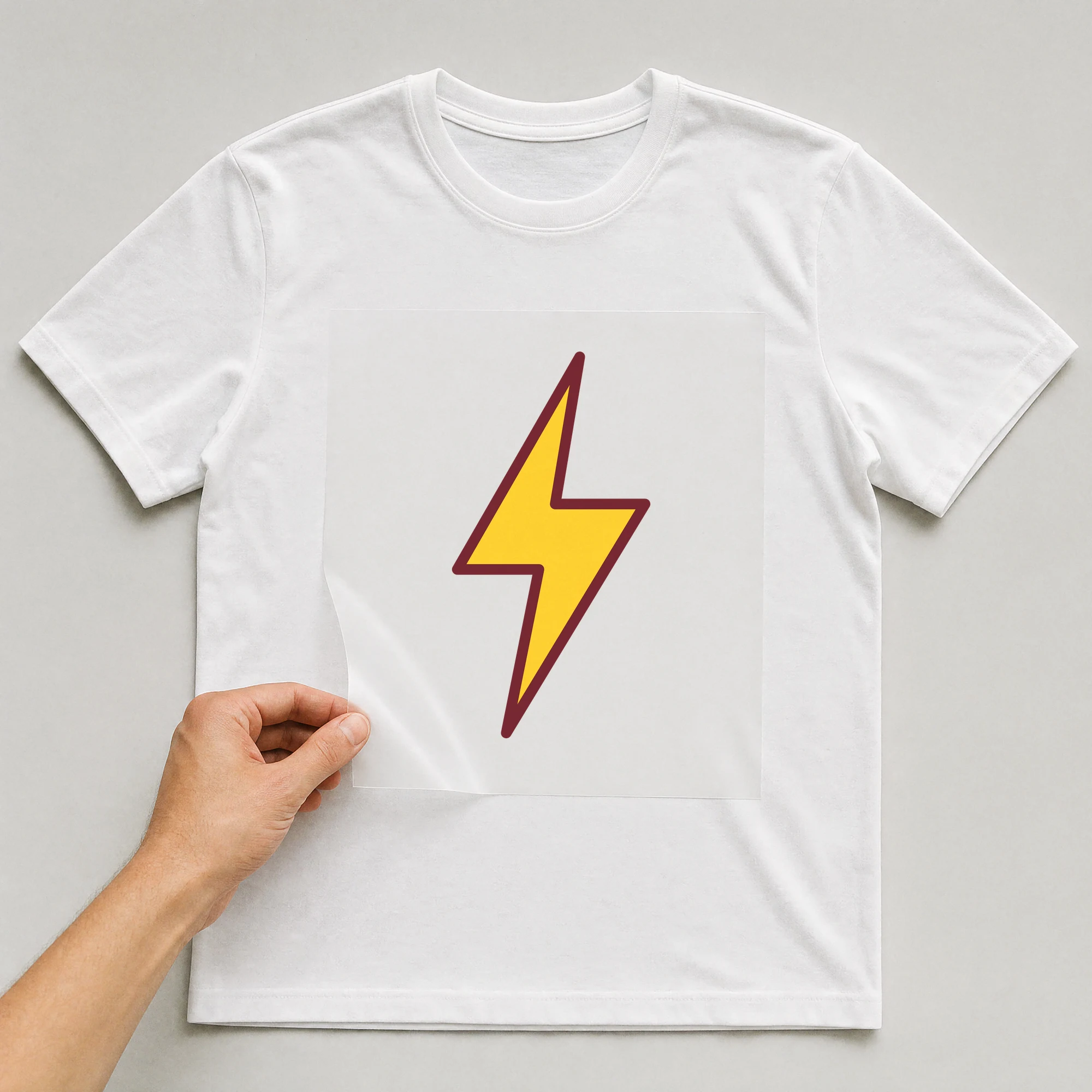 Bügelbild „Blitz“ auf weißem T-Shirt, Folie wird aufgelegt