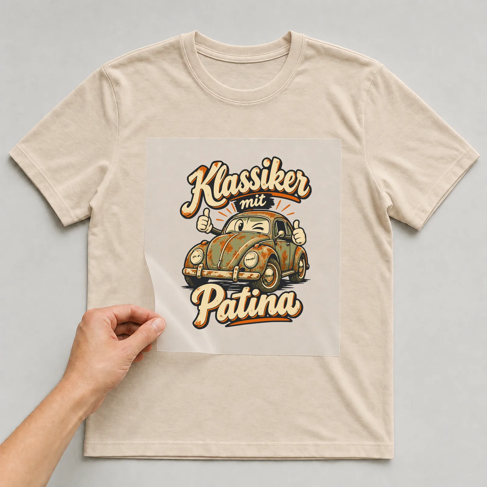 Bügelbild Klassiker mit Patina auf beigem T-Shirt, Folie wird aufgelegt