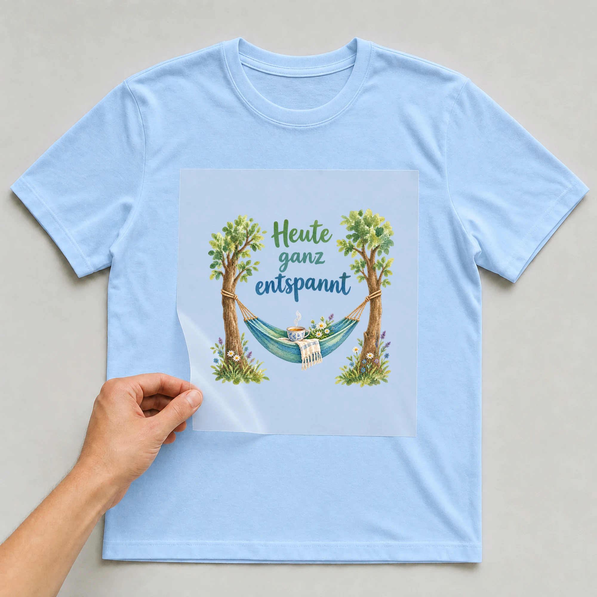 Bügelbild „Heute ganz entspannt“ auf babyblauem T-Shirt, Folie wird aufgelegt