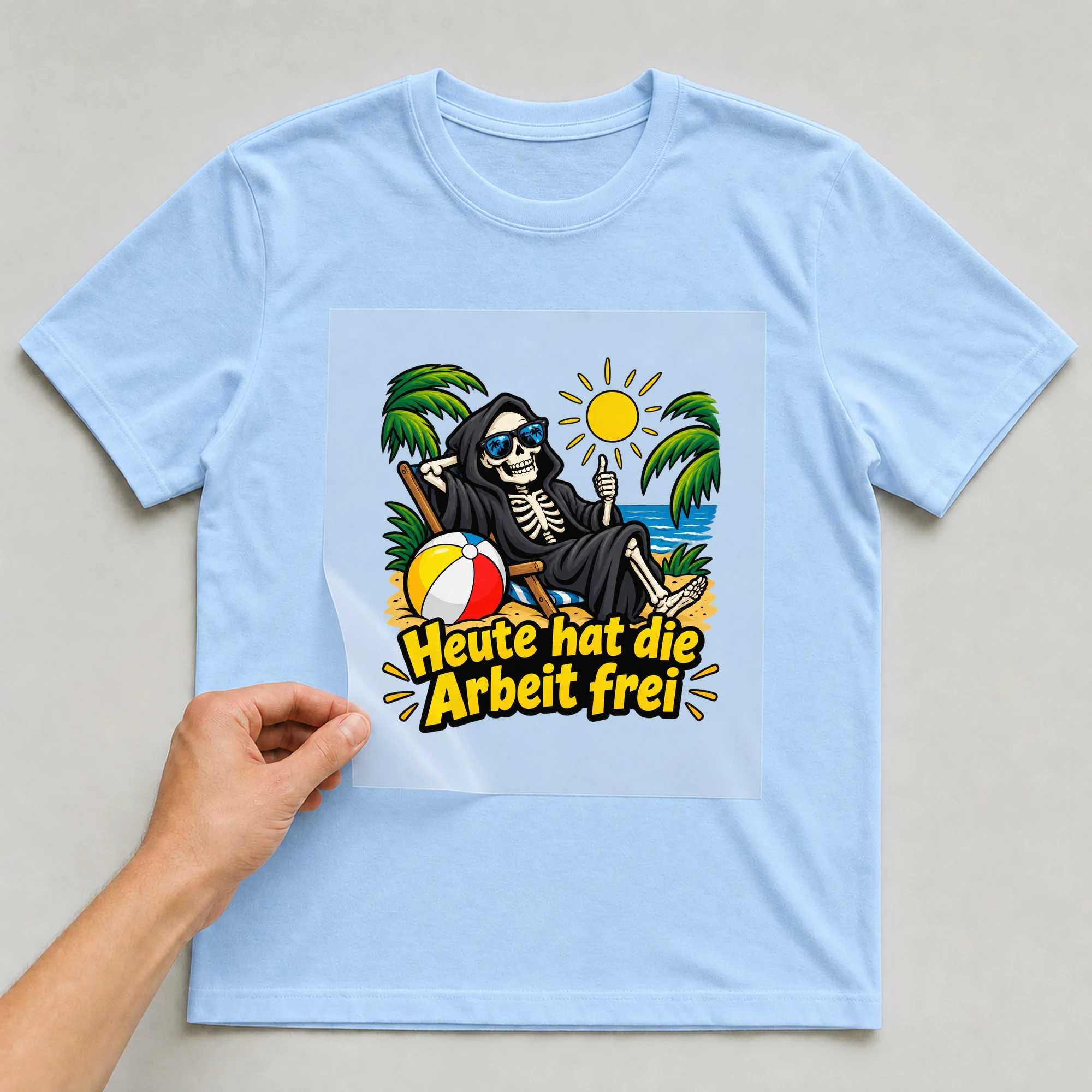 Bügelbild „Heute hat der Tod frei“ auf hellblauem T-Shirt, Folie wird aufgelegt