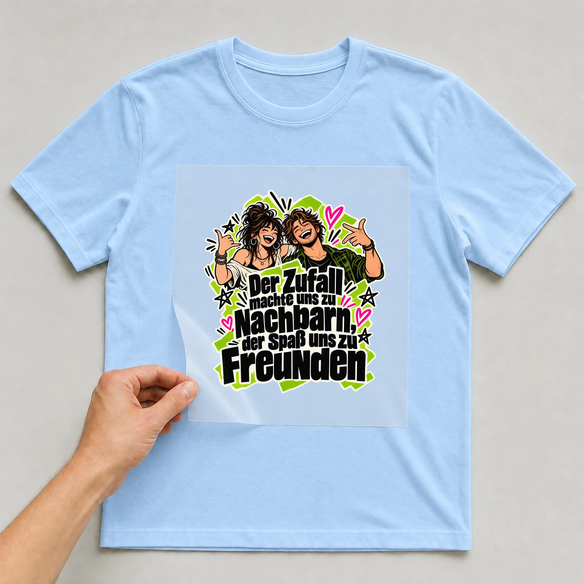 Bügelbild „Der Zufall machte uns zu Nachbarn“ auf babyblauem T-Shirt, Folie wird aufgelegt
