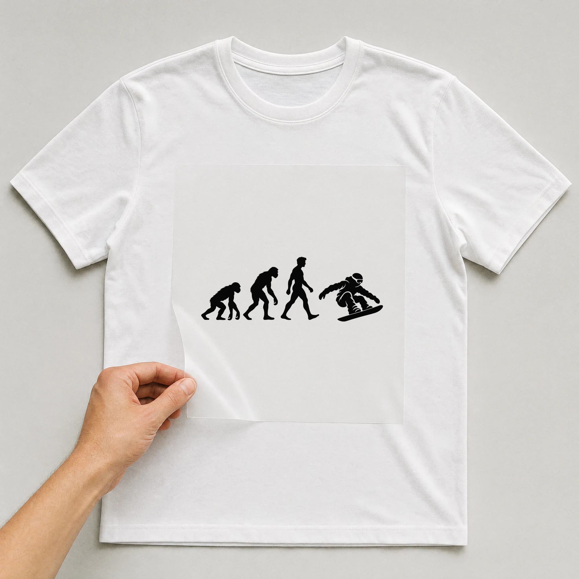 Bügelbild „Evolution Of Snowboarding“ auf weißem T-Shirt, Folie wird aufgelegt