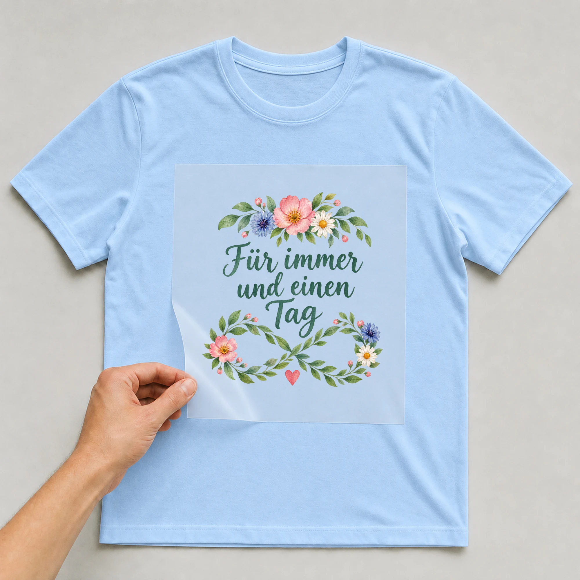 Bügelbild „Für immer und einen Tag“ auf babyblauem T-Shirt, Folie wird aufgelegt