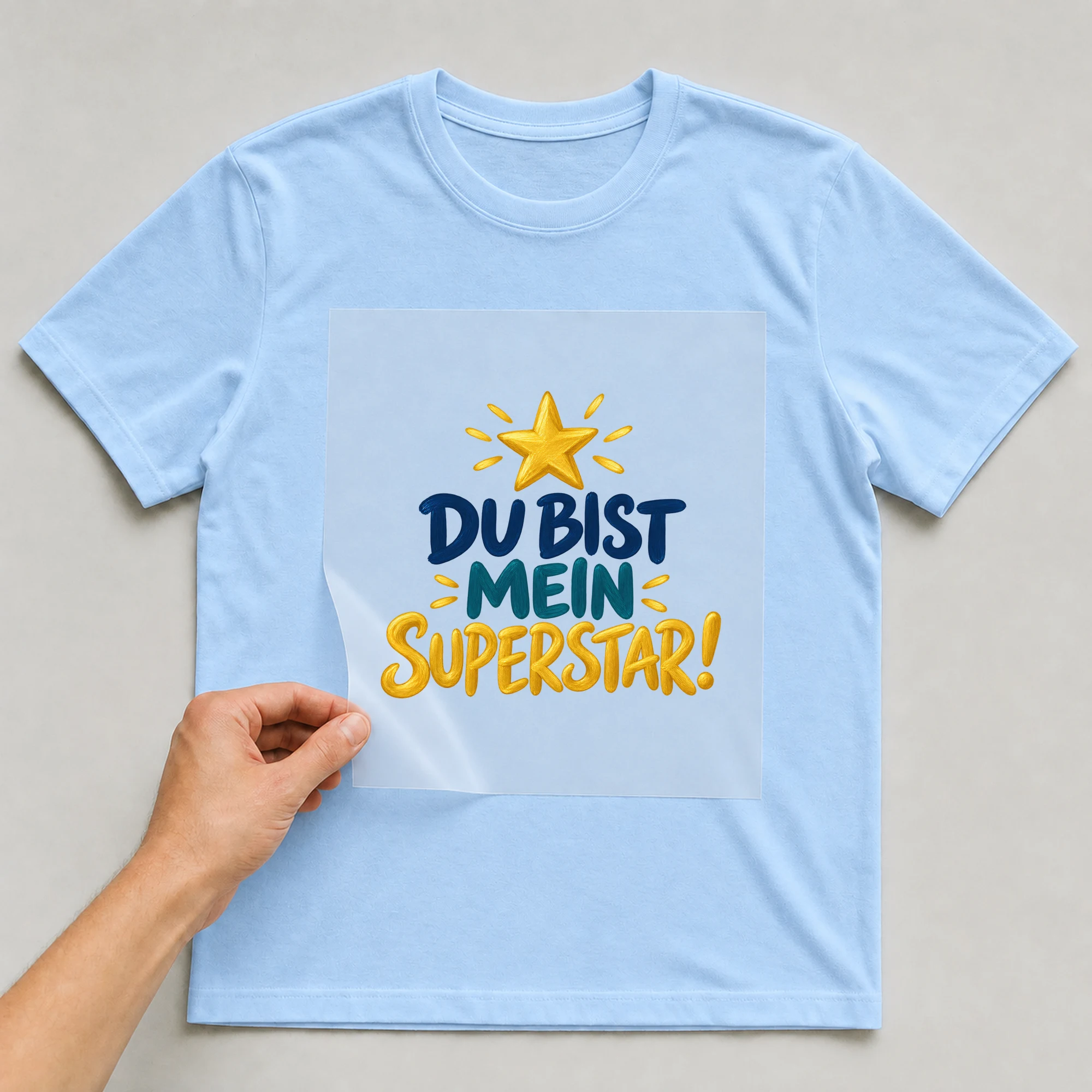 Bügelbild „Du bist mein Superstar!“ auf babyblauem T-Shirt, Folie wird aufgelegt