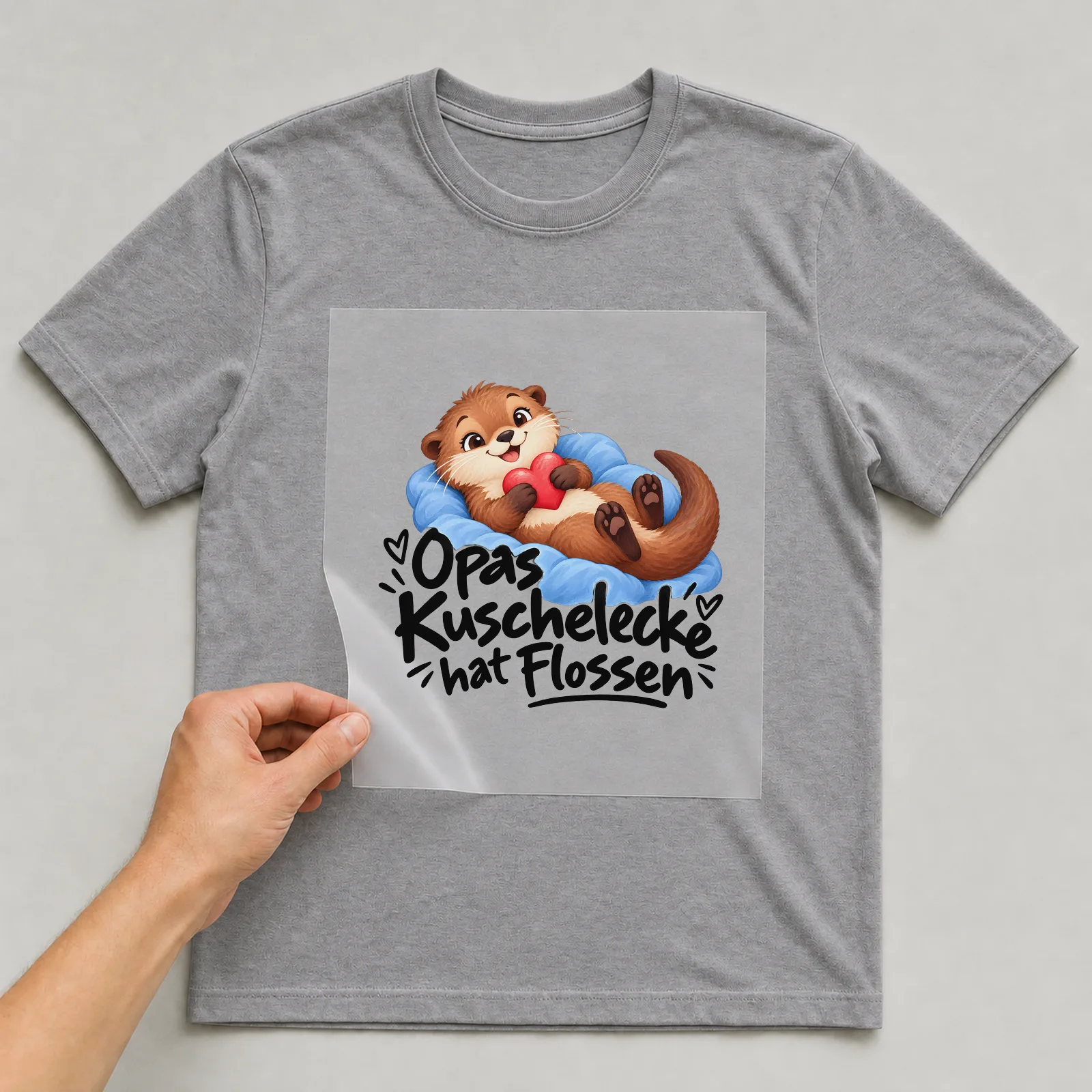 Bügelbild „Opas Kuschelecke hat Flossen“ auf grauem T-Shirt, Folie wird aufgelegt