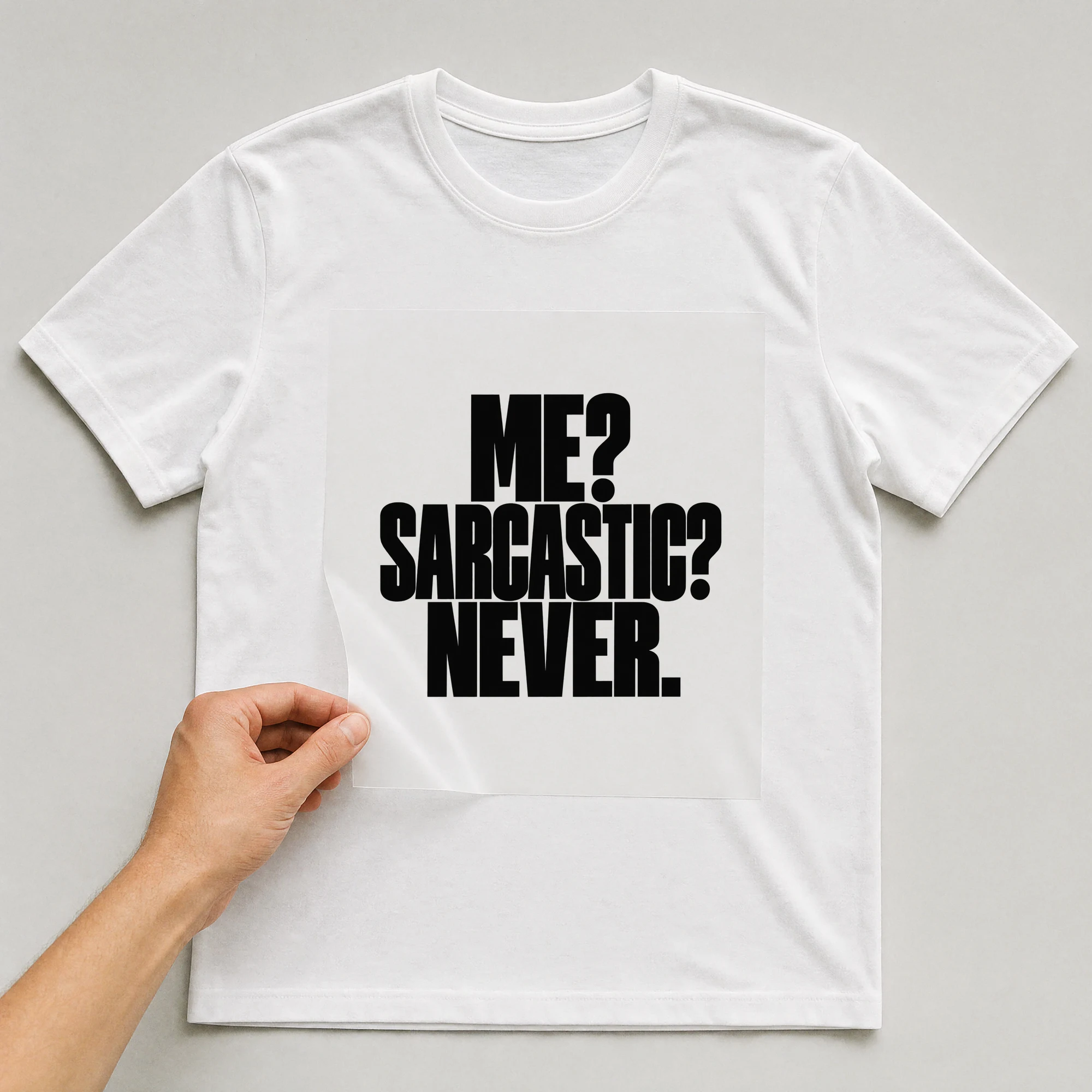 Bügelbild „Me? Sarcastic? Never.“ auf weißem T-Shirt, Folie wird aufgelegt