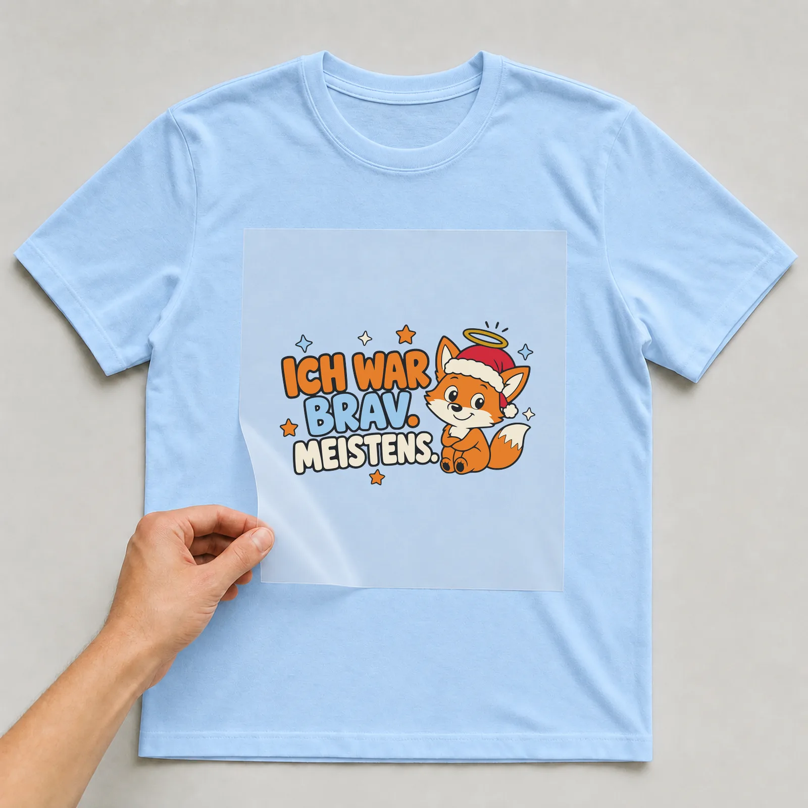Bügelbild Ich war brav. Meistens. auf hellblauem T-Shirt, Folie wird aufgelegt