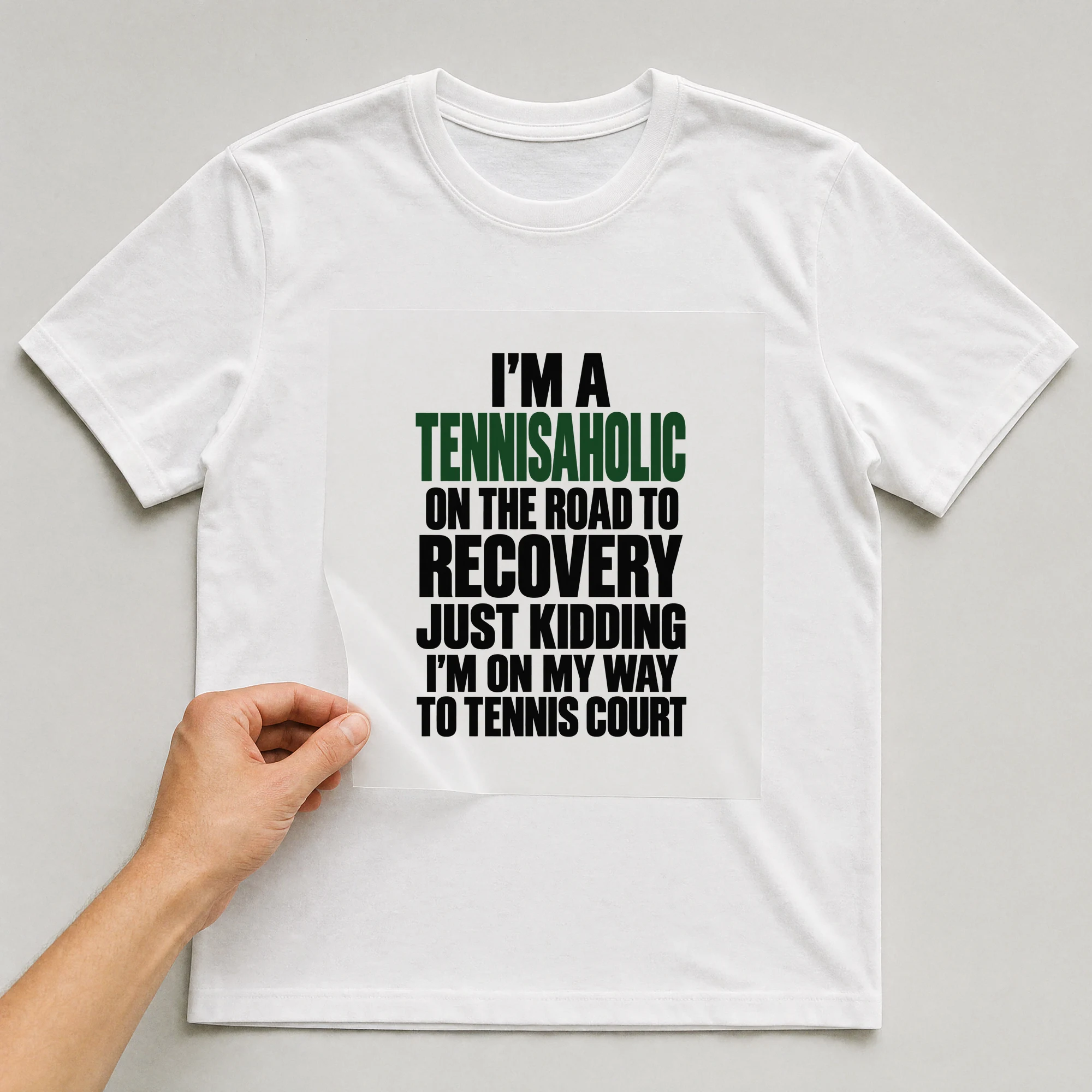 Bügelbild „I'm A Tennisaholic On The Road To Recovery Just Kidding I'm On My Way To“ auf weißem T-Shirt, Folie wird aufgelegt