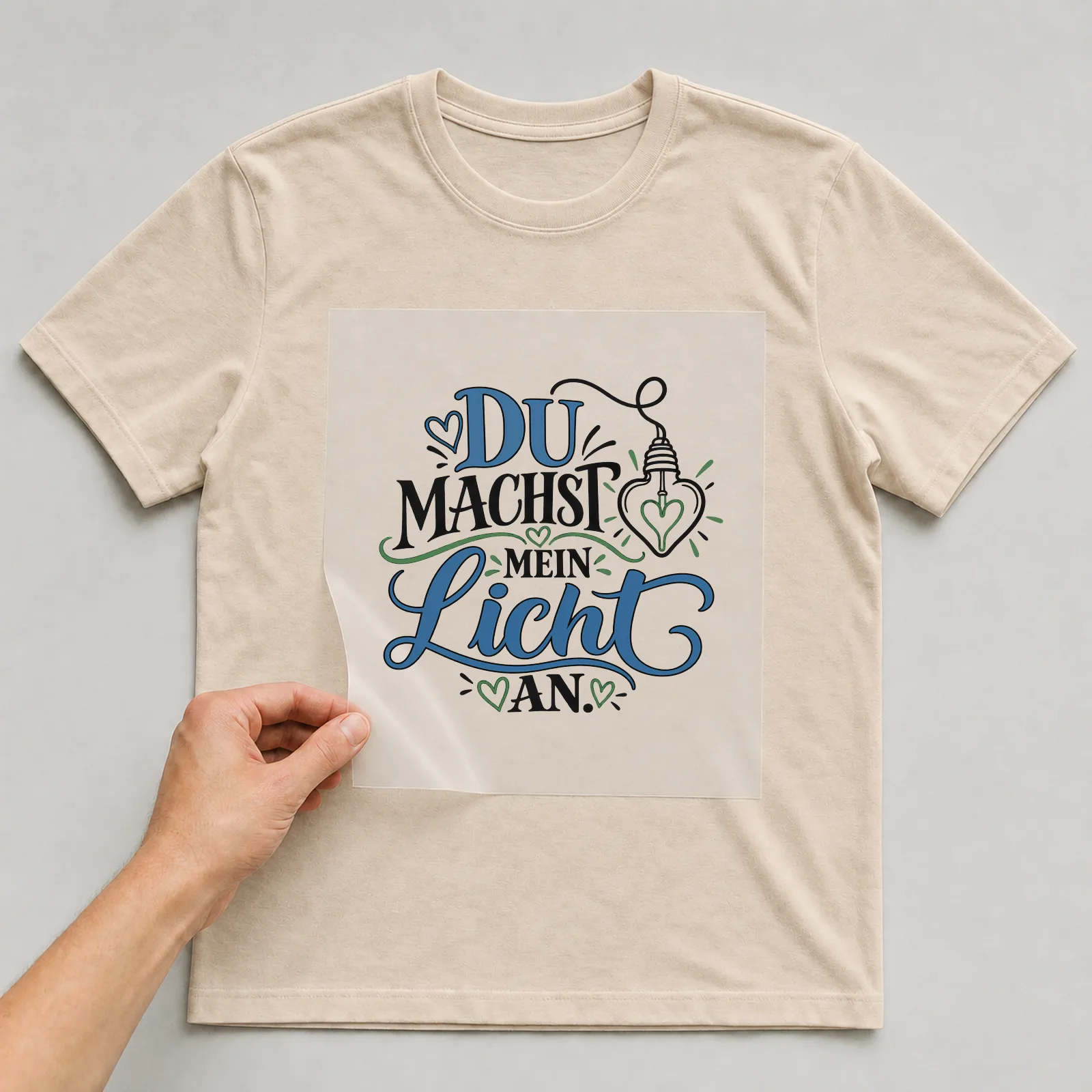 Bügelbild „Du machst mein Licht an“ auf beigem T-Shirt, Folie wird aufgelegt