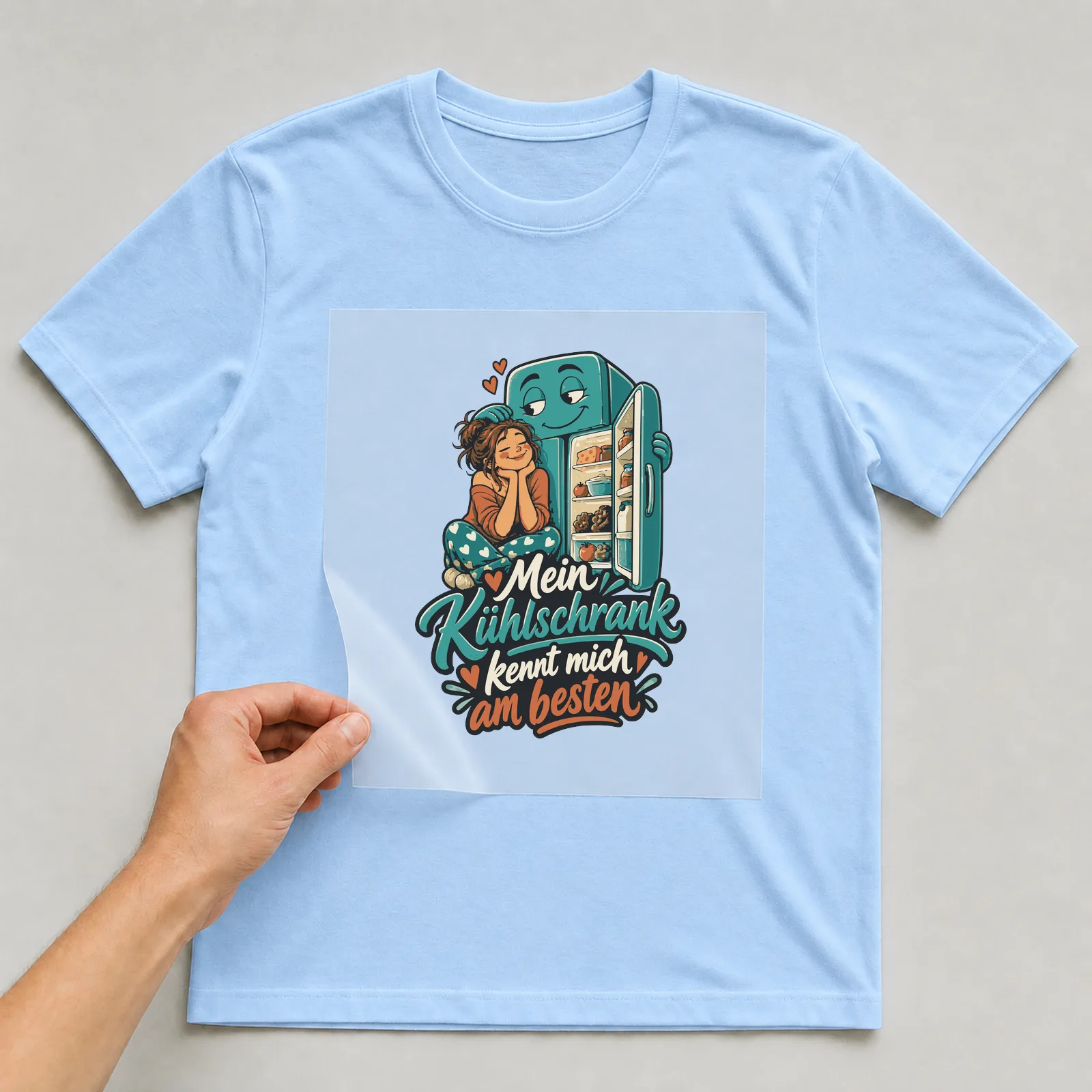 Bügelbild Mein Kühlschrank kennt mich am besten auf hellblauem T-Shirt, Folie wird aufgelegt