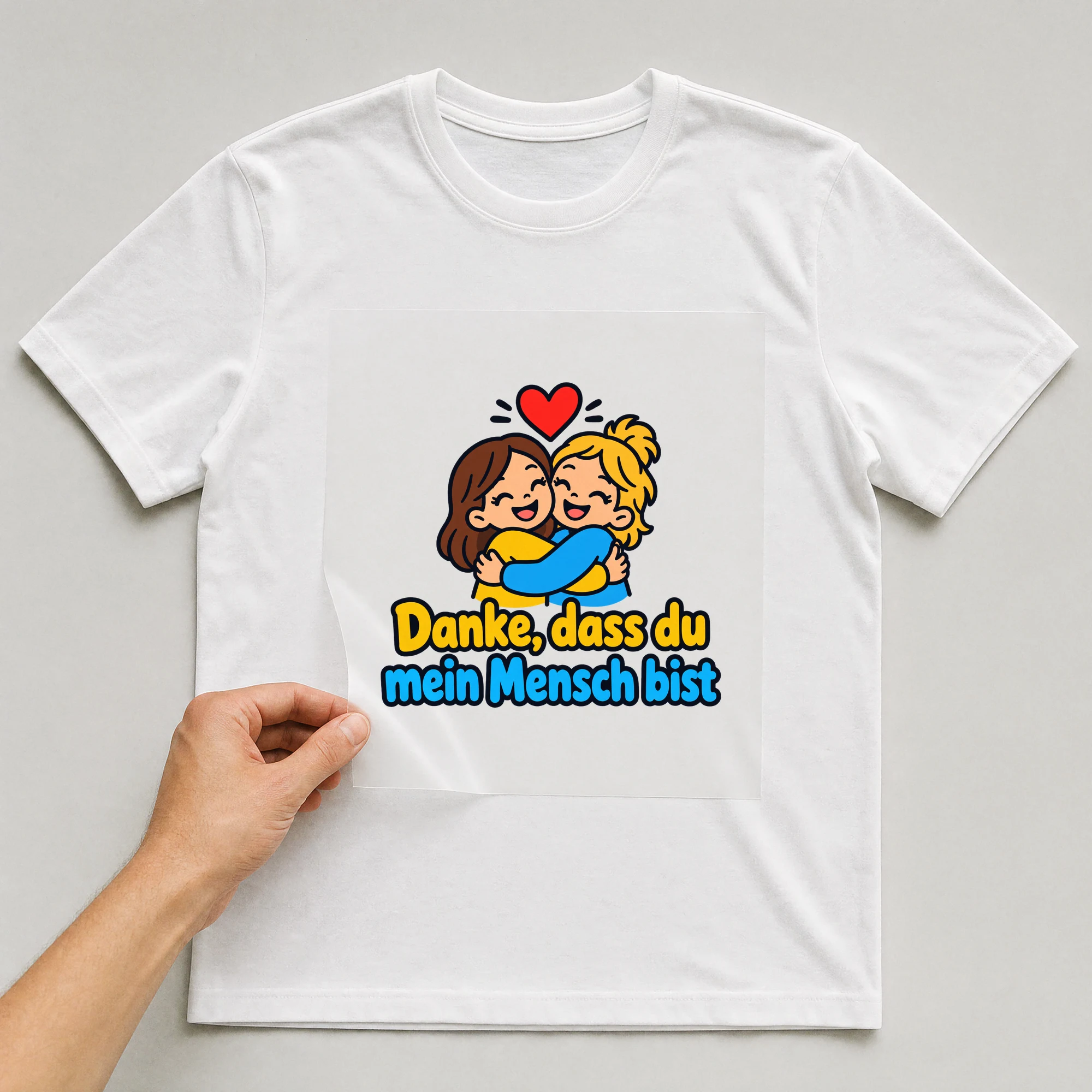 Bügelbild „Danke, dass du mein Mensch bist“ auf weißem T-Shirt, Folie wird aufgelegt