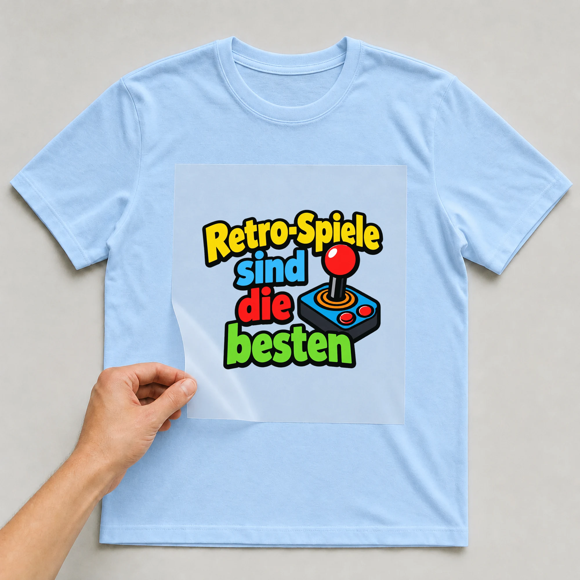 Bügelbild „Retro-Spiele sind die besten“ auf babyblauem T-Shirt, Folie wird aufgelegt