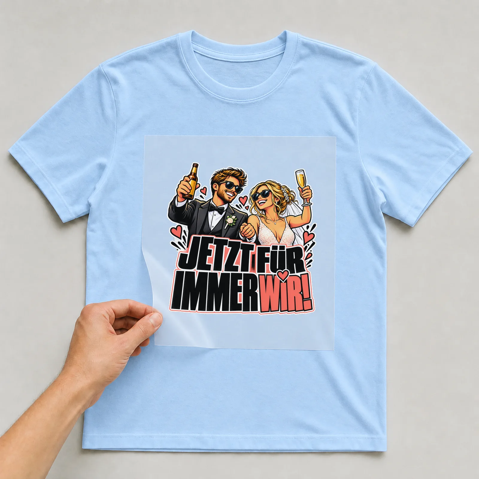 Bügelbild „Jetzt für immer wir!“ auf hellblauem T-Shirt, Folie wird aufgelegt