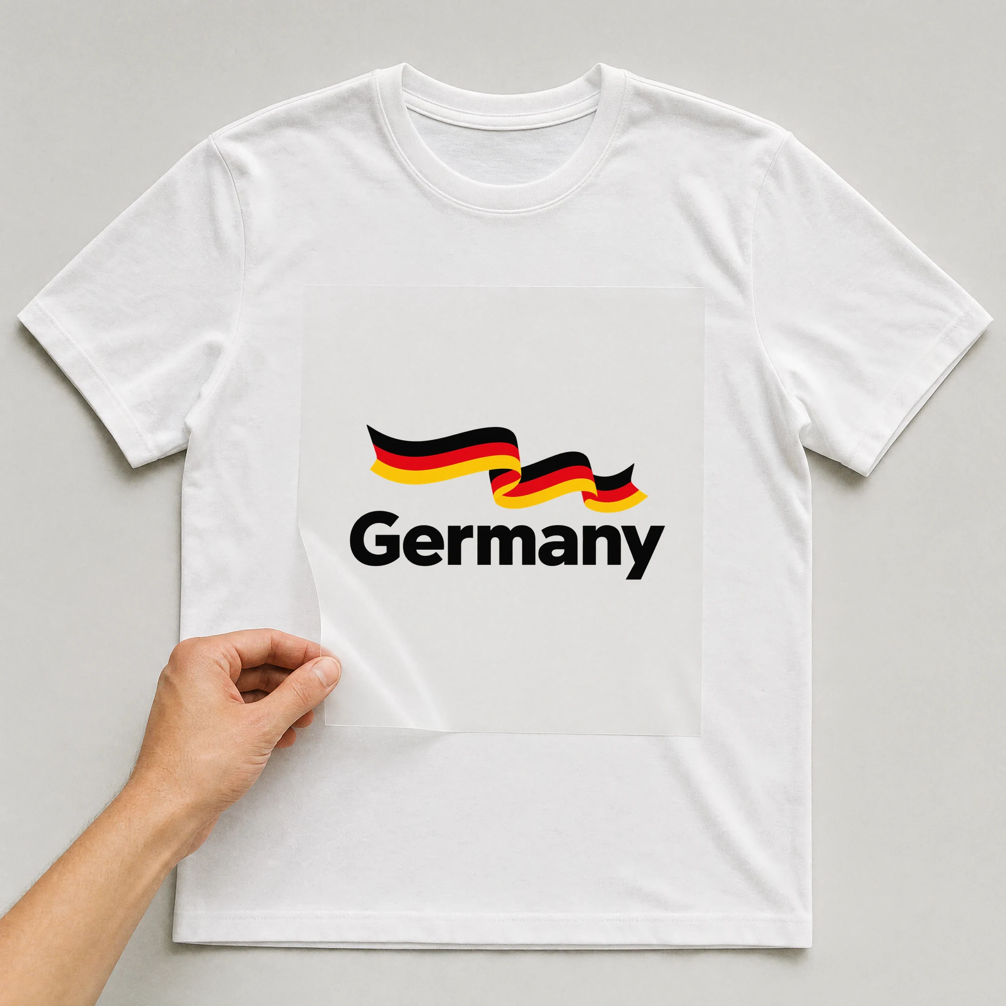 Bügelbild „Germany“ auf weißem T-Shirt, Folie wird aufgelegt