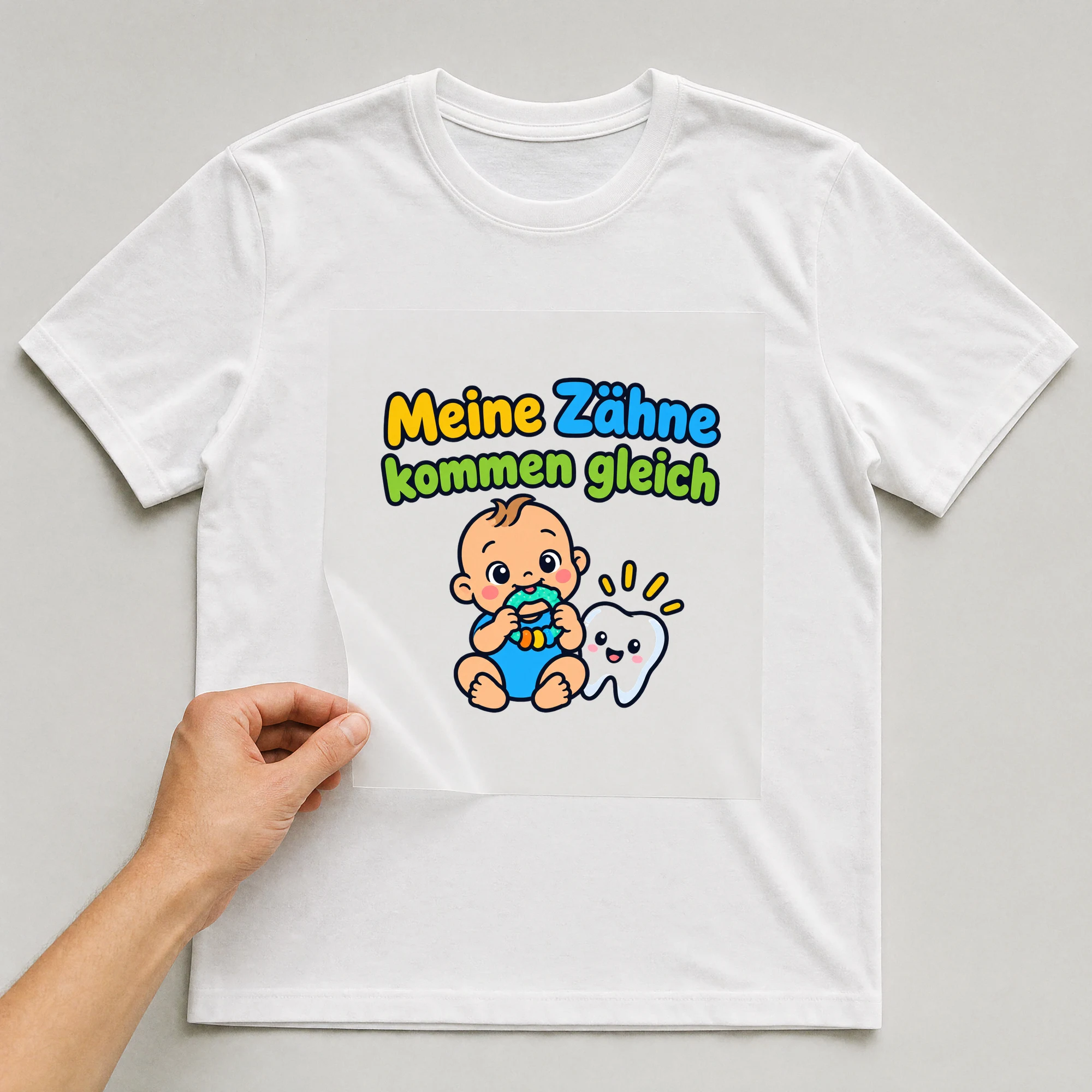 Bügelbild „Meine Zähne kommen gleich“ auf weißem T-Shirt, Folie wird aufgelegt