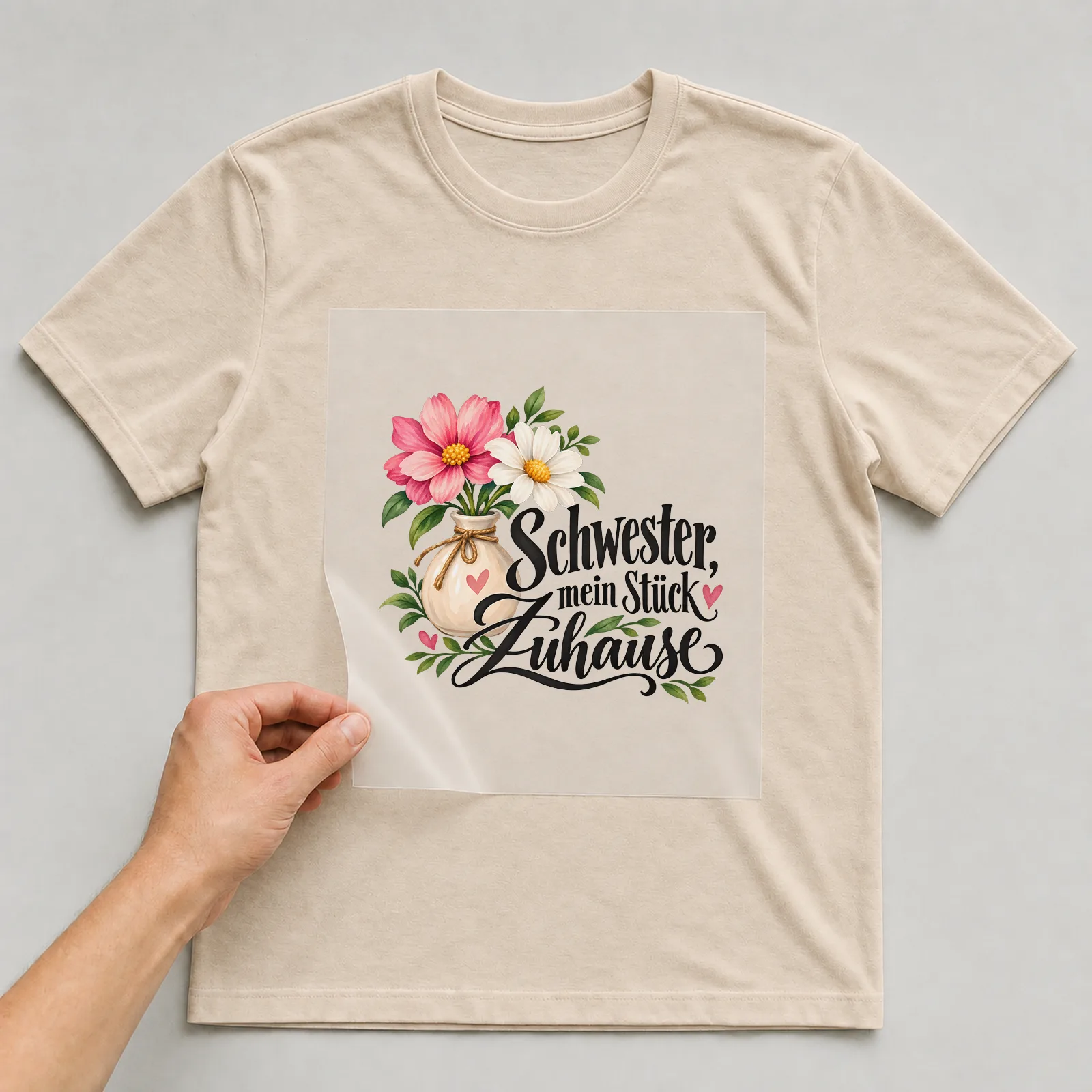 Bügelbild „Schwester, mein Stück Zuhause“ auf beigem T-Shirt, Folie wird aufgelegt