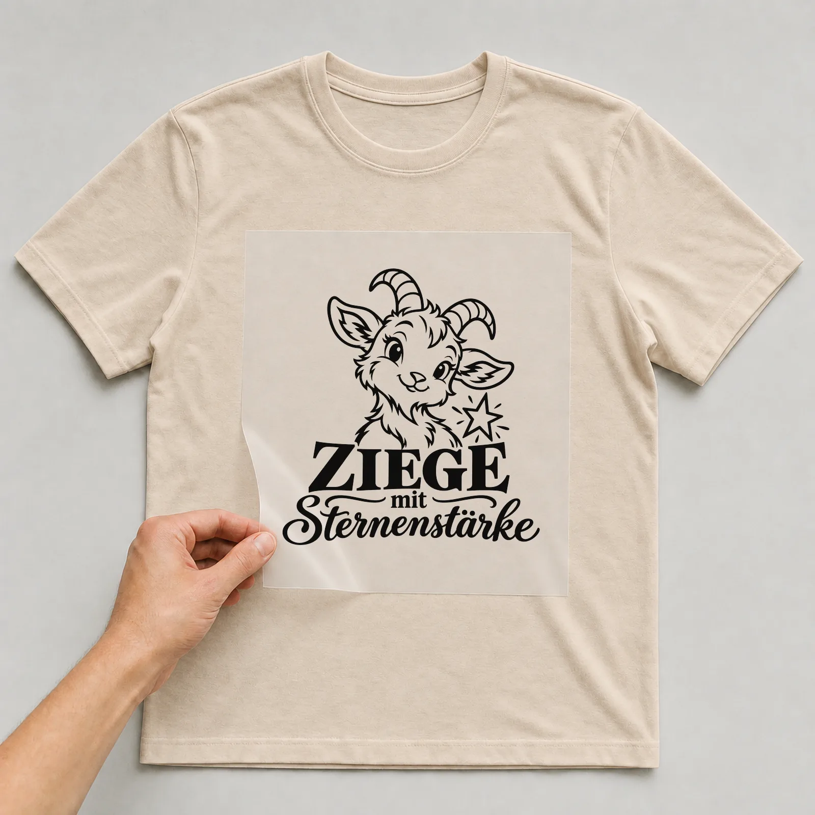 Bügelbild „Ziege mit Sternenstärke“ auf beigem T-Shirt, Folie wird aufgelegt