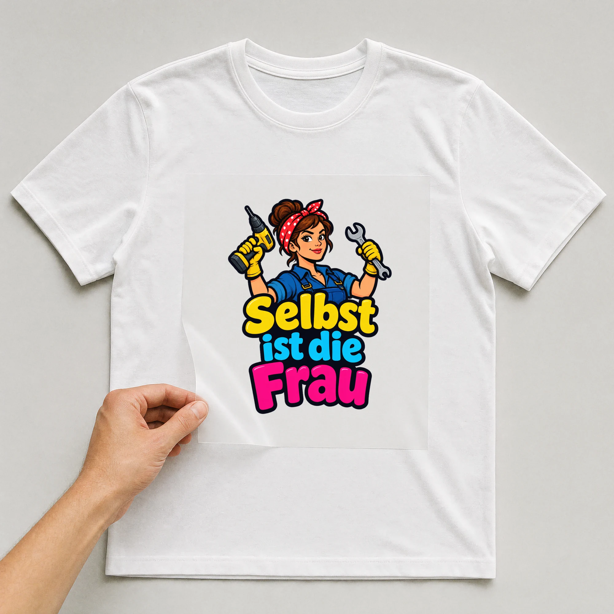 Bügelbild „Selbst ist die Frau“ auf weißem T-Shirt, Folie wird aufgelegt