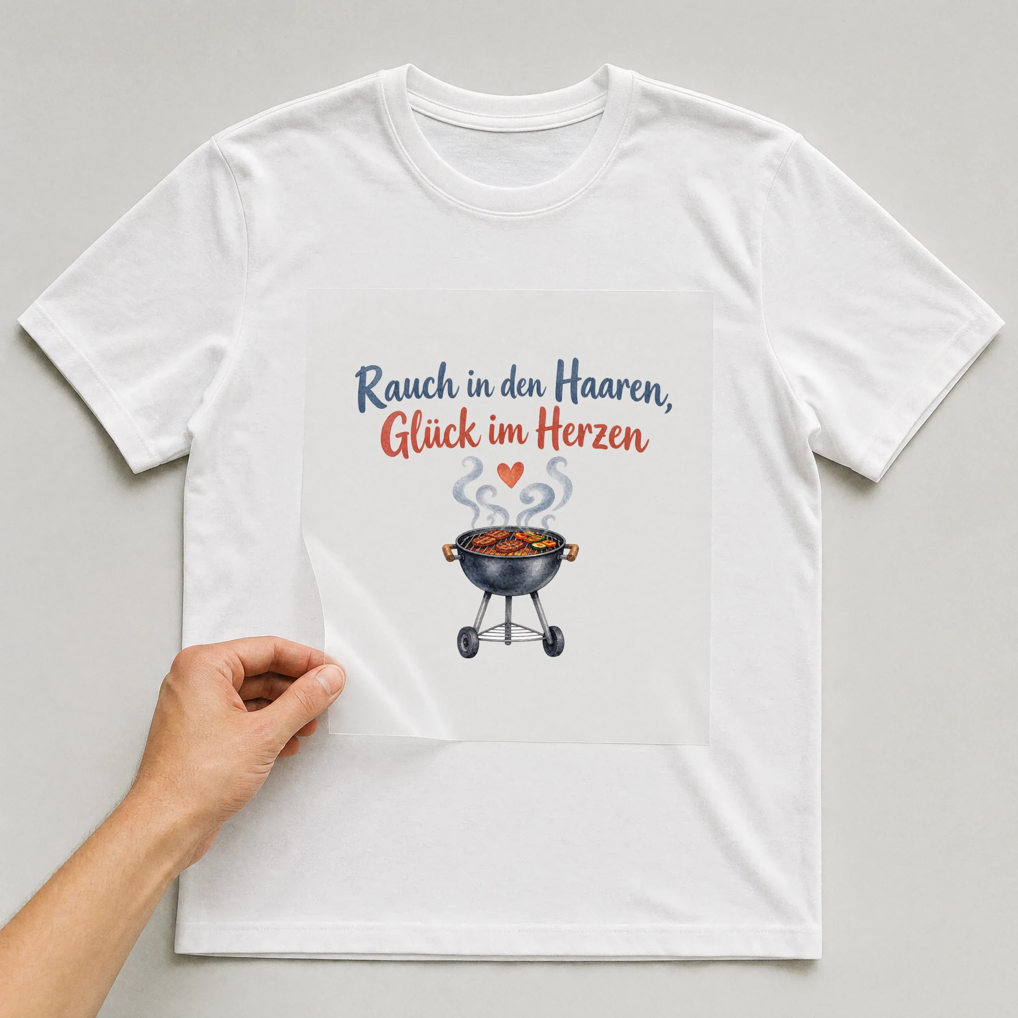 Bügelbild „Rauch in den Haaren, Glück im Herzen“ auf weißem T-Shirt, Folie wird aufgelegt