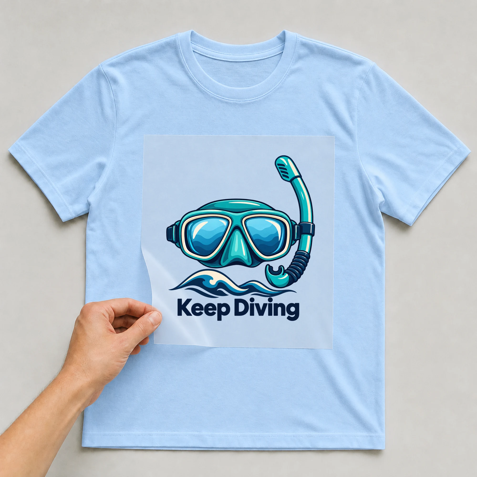 Bügelbild „Keep Diving“ auf babyblauem T-Shirt, Folie wird aufgelegt