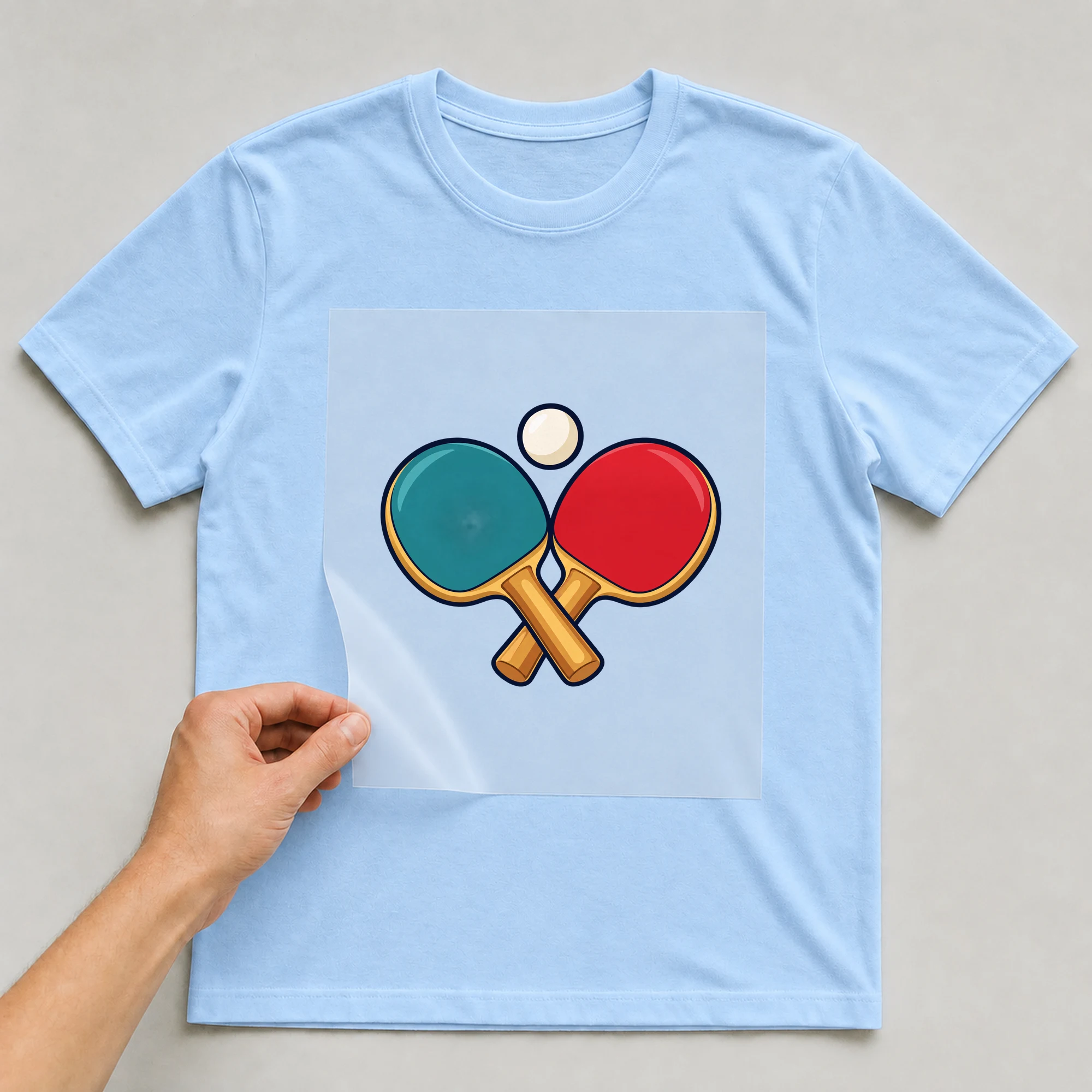 Bügelbild „Tischtennis Retro“ auf babyblauem T-Shirt, Folie wird aufgelegt