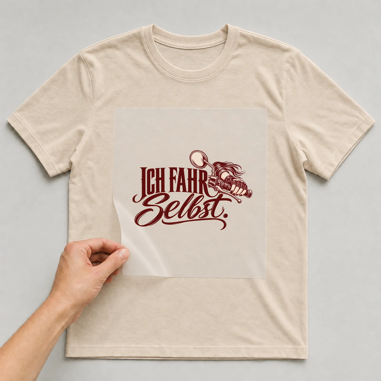 Bügelbild „Ich fahr selbst“ auf beigem T-Shirt, Folie wird aufgelegt