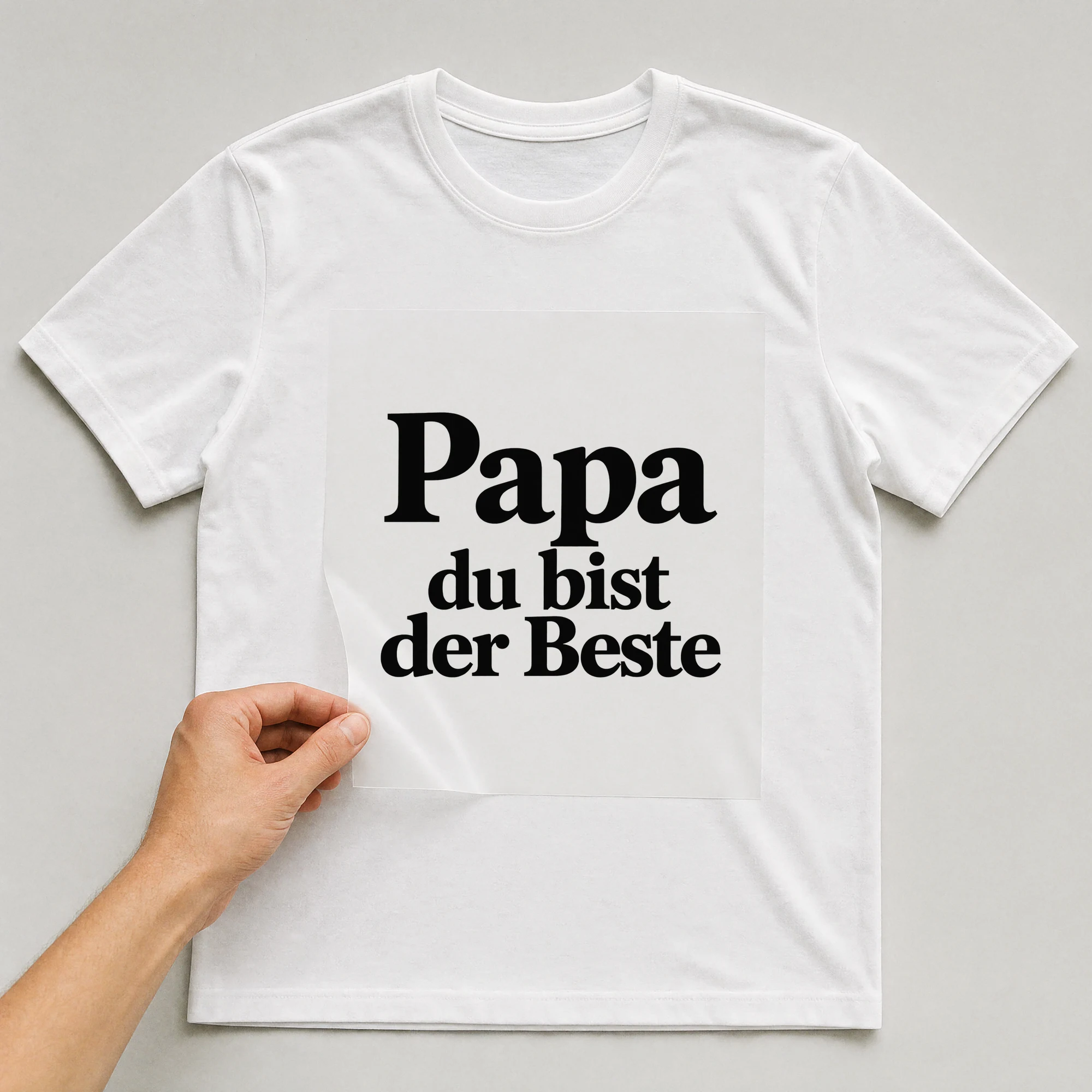 Bügelbild „Papa du bist der Beste“ auf weißem T-Shirt, Folie wird aufgelegt