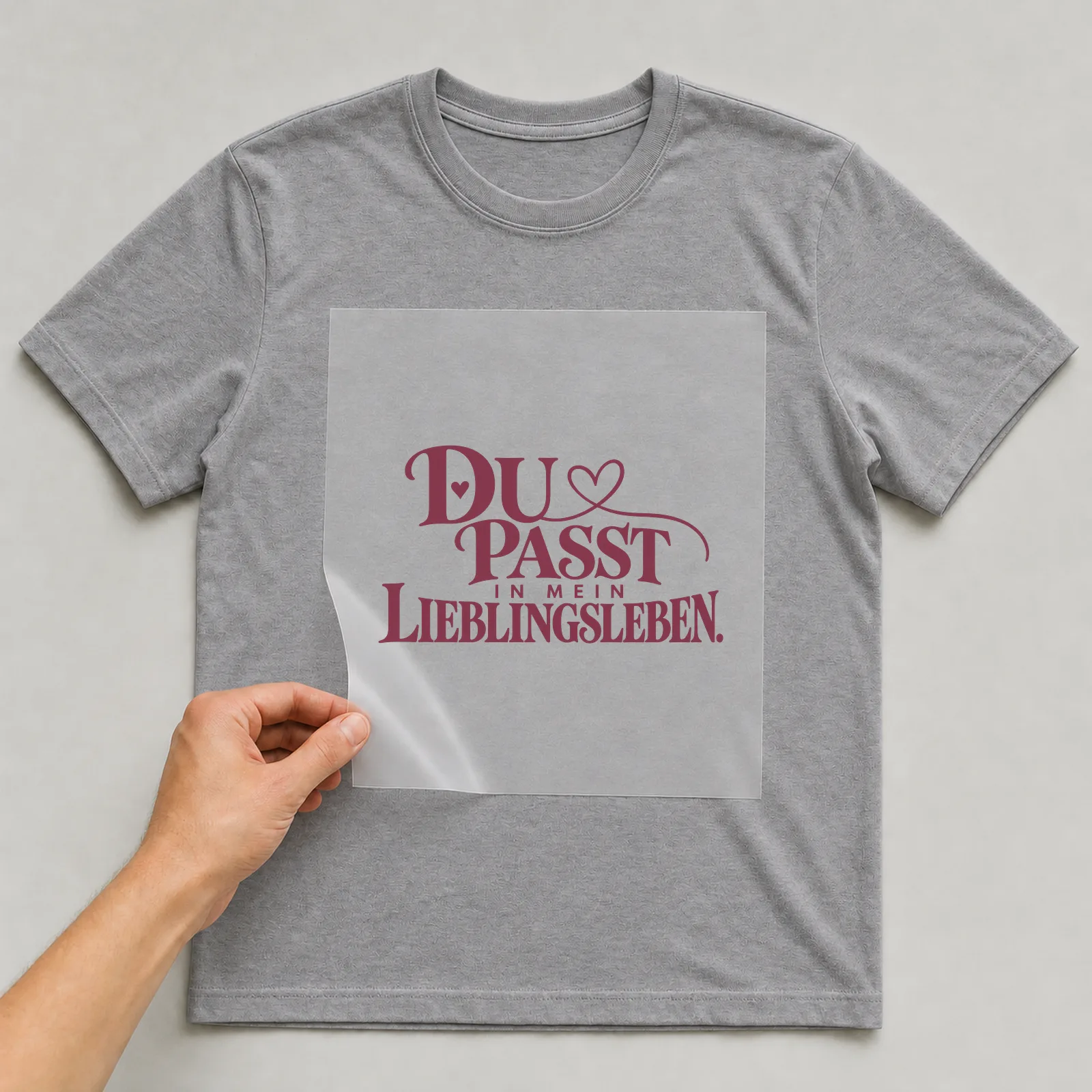 Bügelbild „Du passt in mein Lieblingsleben“ auf grauem T-Shirt, Folie wird aufgelegt