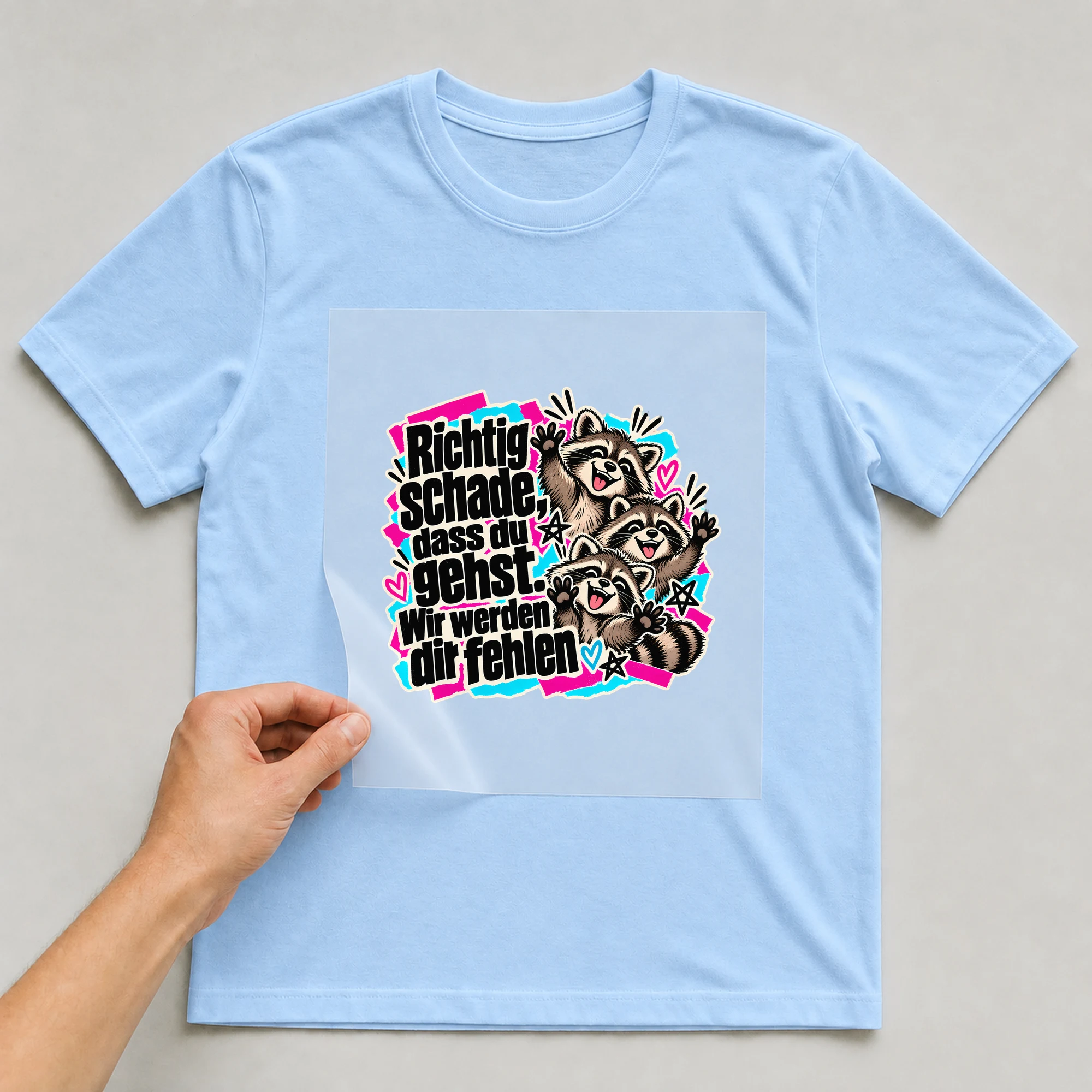 Bügelbild „Richtig schade, dass du gehst. Wir werden dir fehlen“ auf babyblauem T-Shirt, Folie wird aufgelegt
