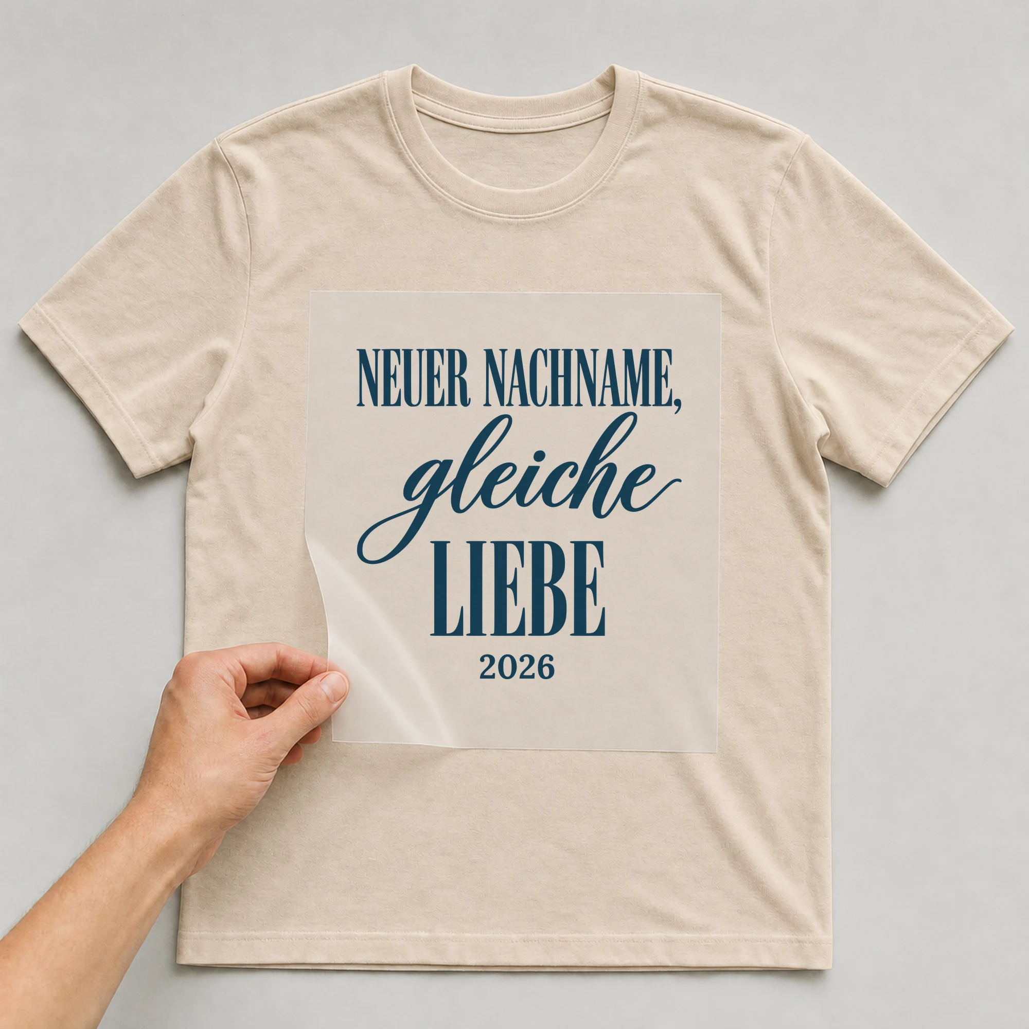 Bügelbild Neuer Nachname, gleiche Liebe auf beigem T-Shirt, Folie wird aufgelegt